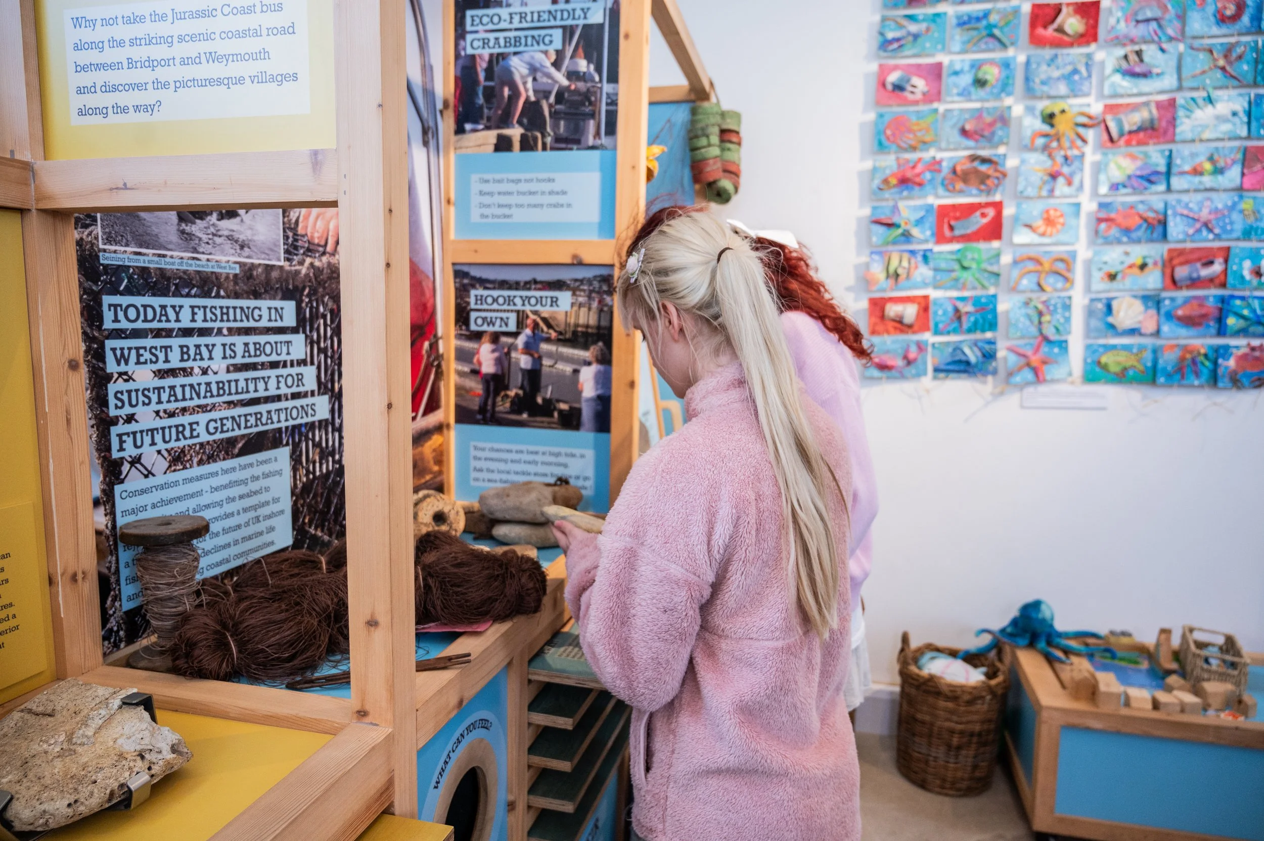 two people looking at a west bay fishing exhibition 