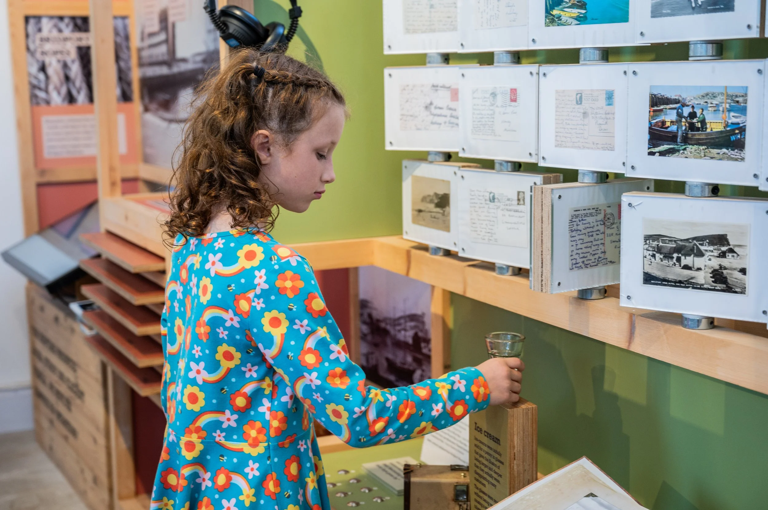 a young girl looking at a display she is holding a glass object 