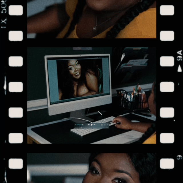 A woman sits at a desk with an iMac computer, looking at a photo of herself on the screen, surrounded by office supplies and photo prints.