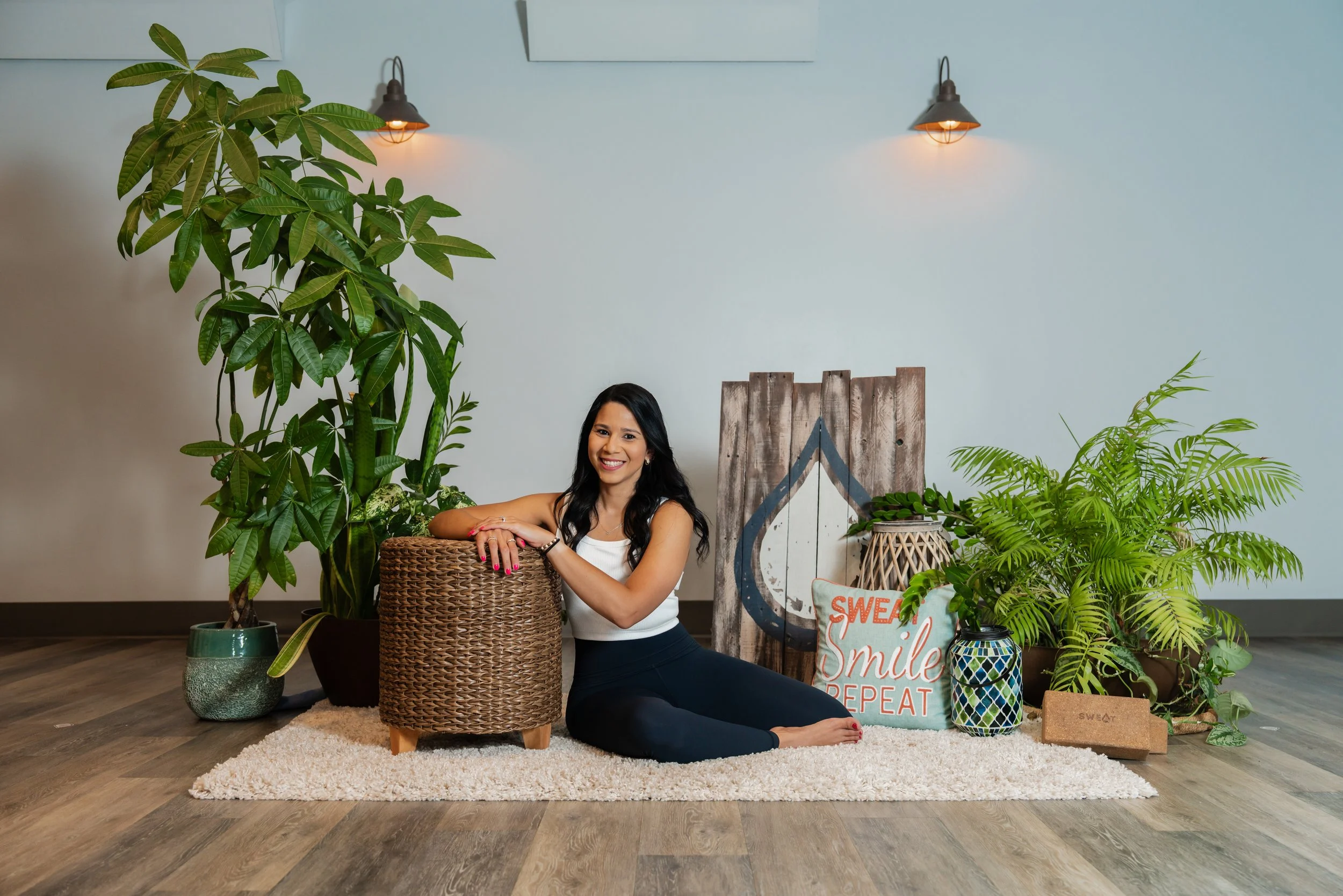 Aixa Perez Coulter smiling while sitting cross-legged on the floor