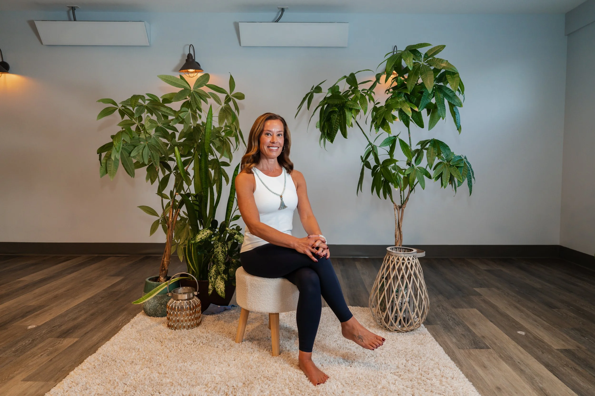 Nicole Ghedini sitting in a chair and hugging a pillow with a bright smile