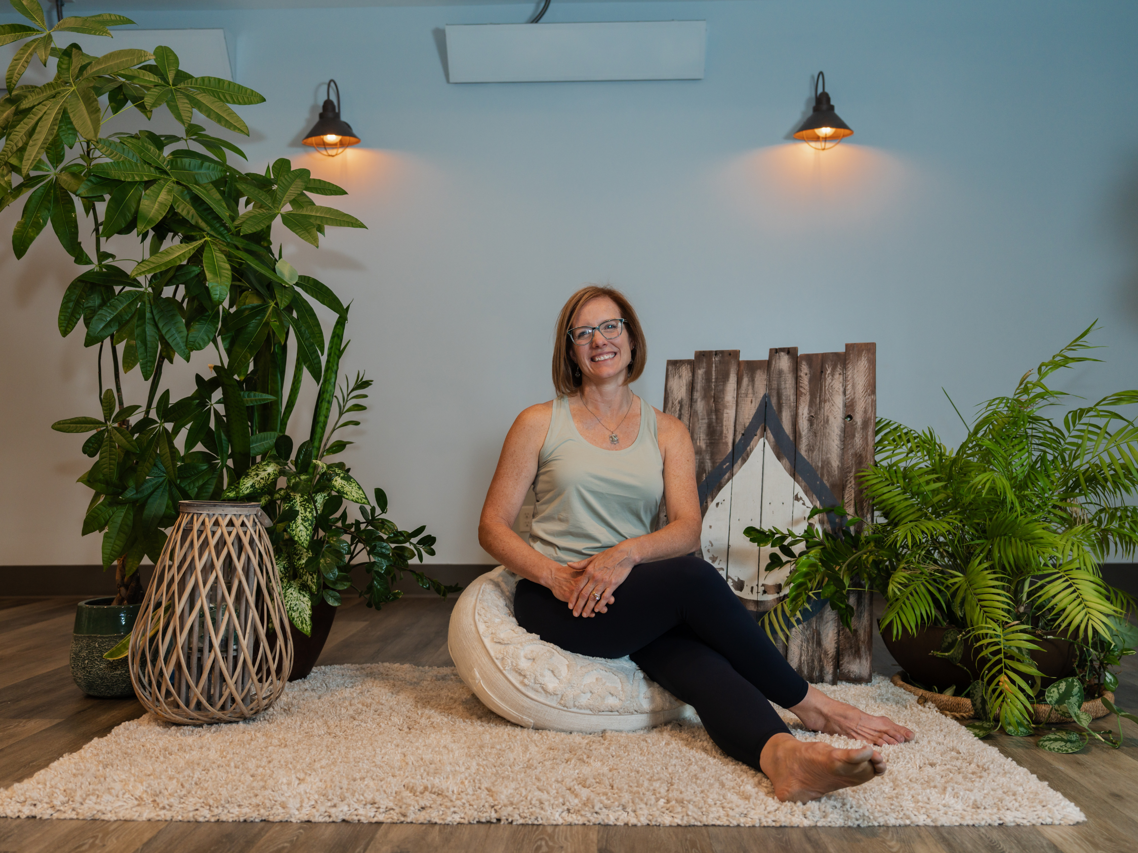 Lynn Weppler smiling brightly while sitting on a wicker cushion