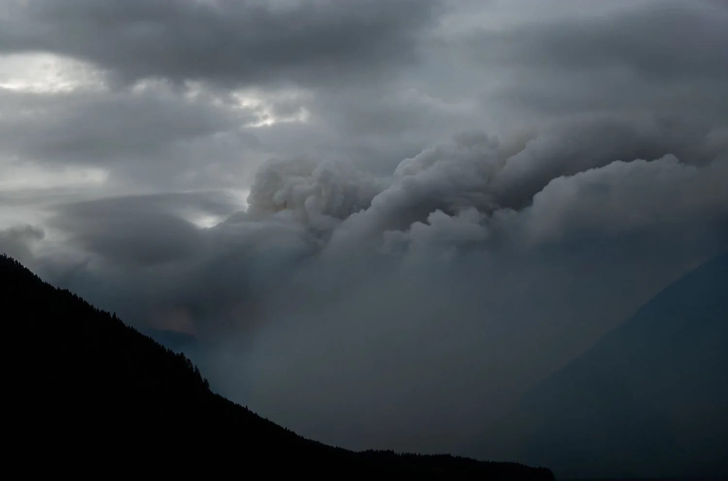 The Bear Gulch Fire burns behind Lake Cushman in Washington State, USA on August 5, 2025.