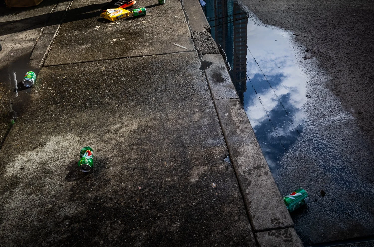 Buildings reflect in a puddle at the bus stops on 3rd Avenue and Pike Street in Seattle, Washington, USA on March 11, 2023.