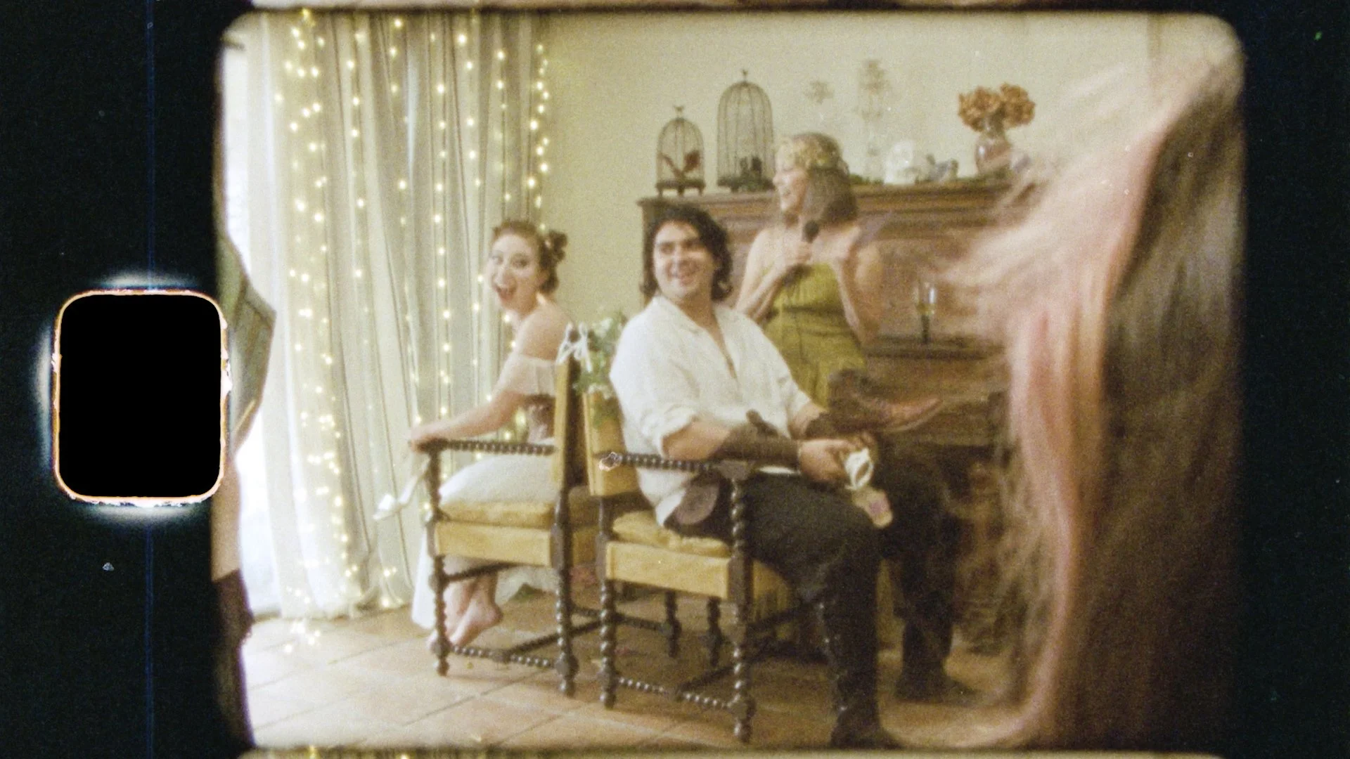 Nearlyweds sit back to back laughing during a game at their joint couples shower months before their wedding. The shower was renaissance themed.