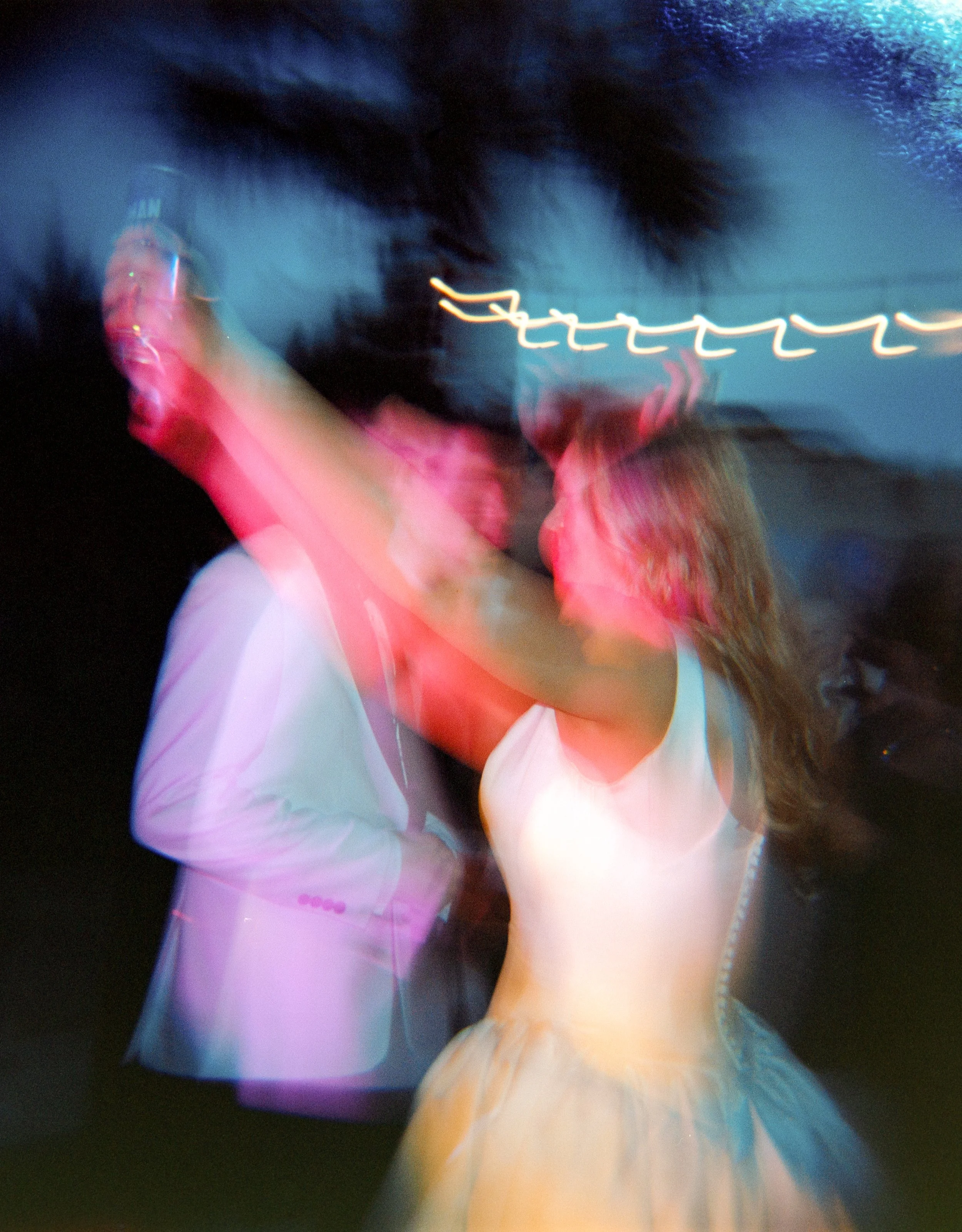 A newlywed couple dance together at their outdoor wedding reception in Texas.