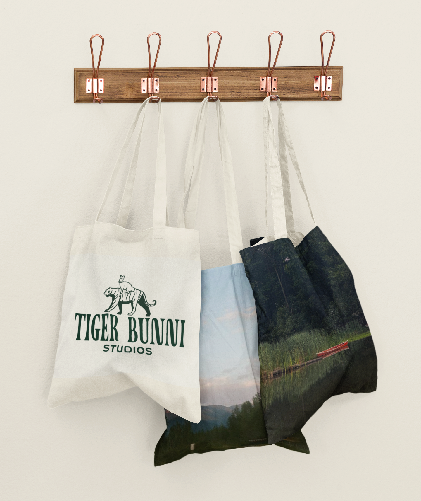 mockup-of-three-customizable-tote-bags-hanging-against-a-solid-color-wall-41717-r-el2.png