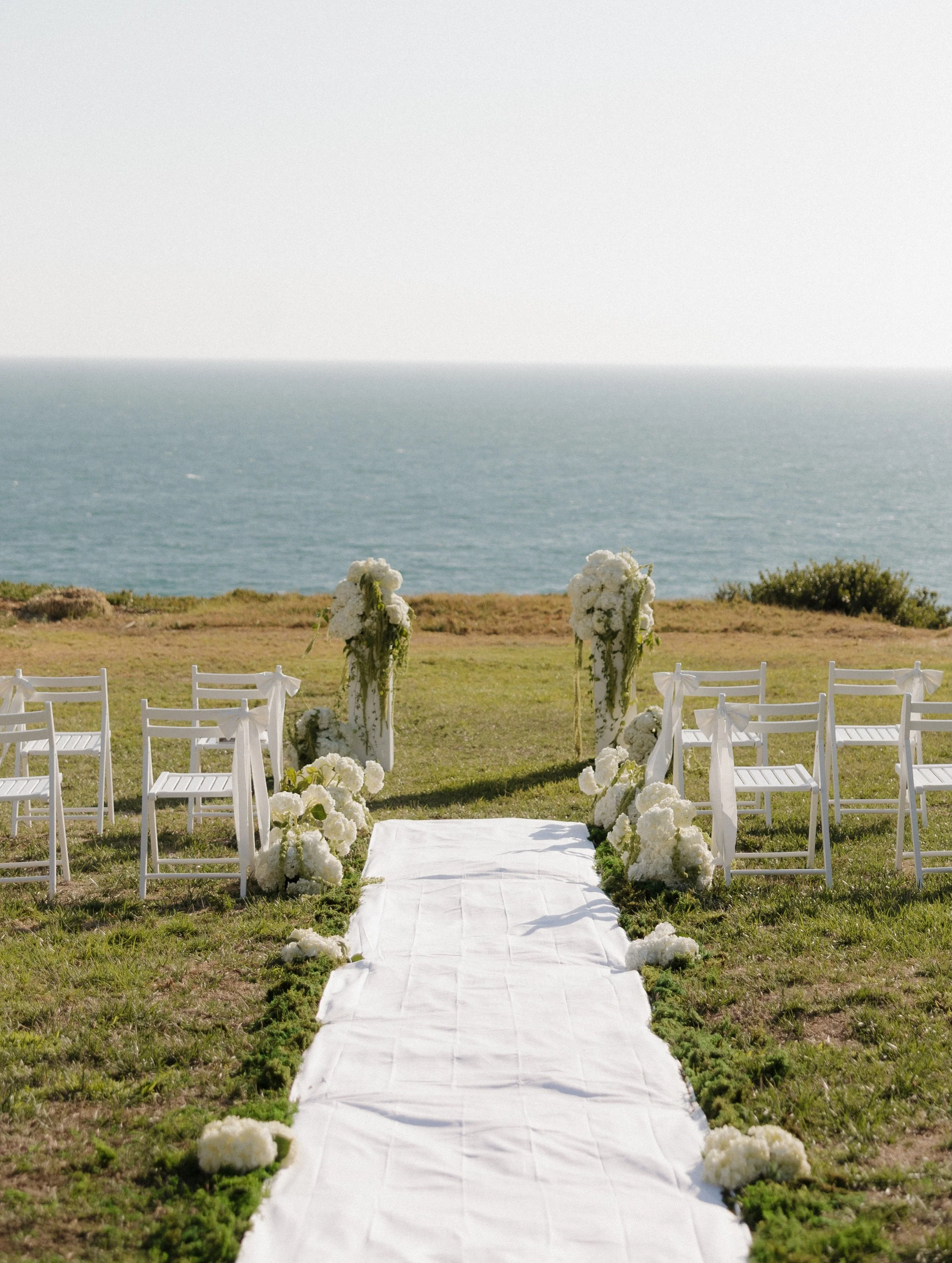 Micro wedding season is here &amp; we are here for it✨
White chairs, ocean views, simple
florals, &amp; marrying the love of your life.

Planner: @sierrajamesevents
Photographer: @brittaneetphoto
Videographer: @thehowardsfilmco
Florist: @solstice_blo