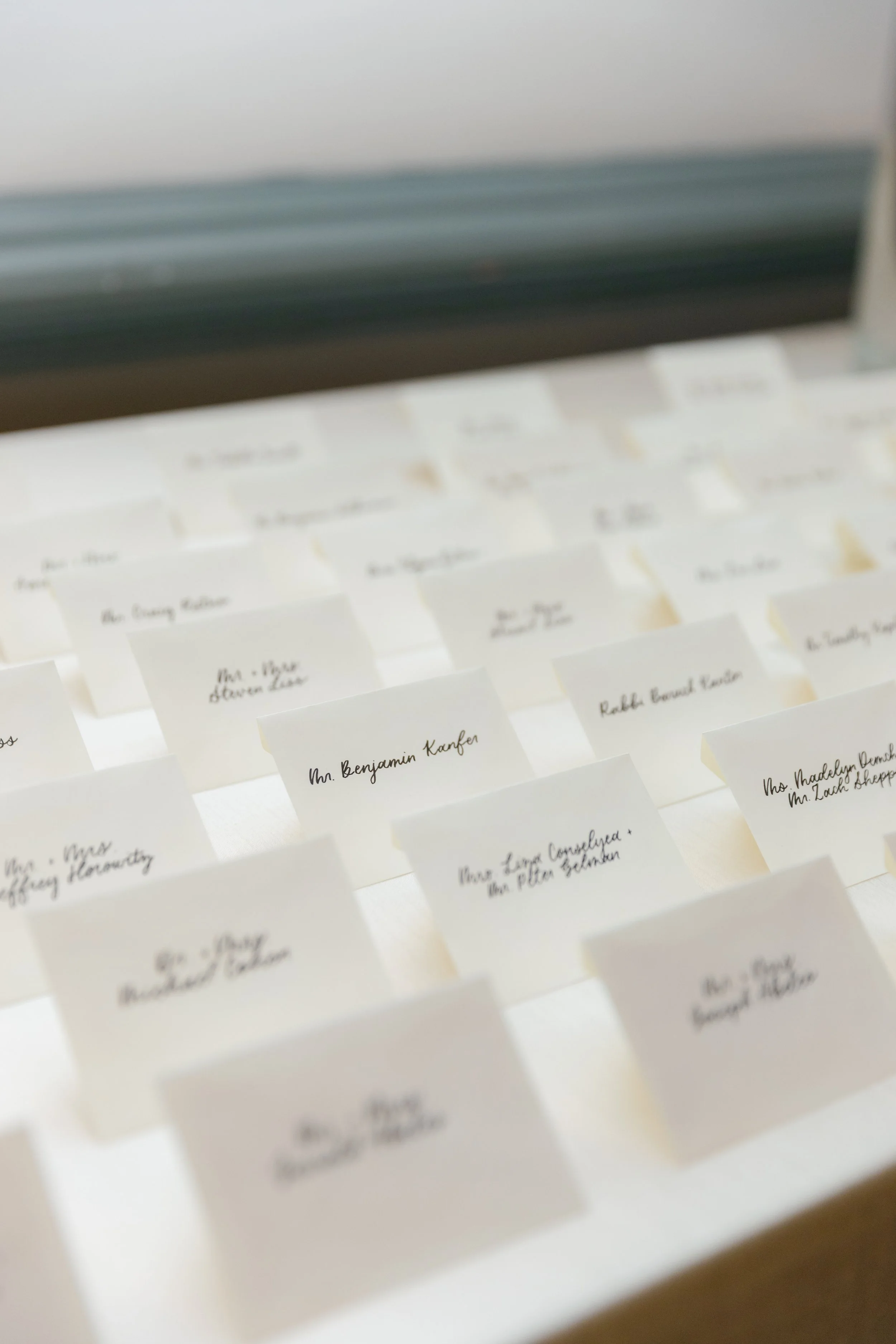 Escort cards in modern calligraphy on white envelopes