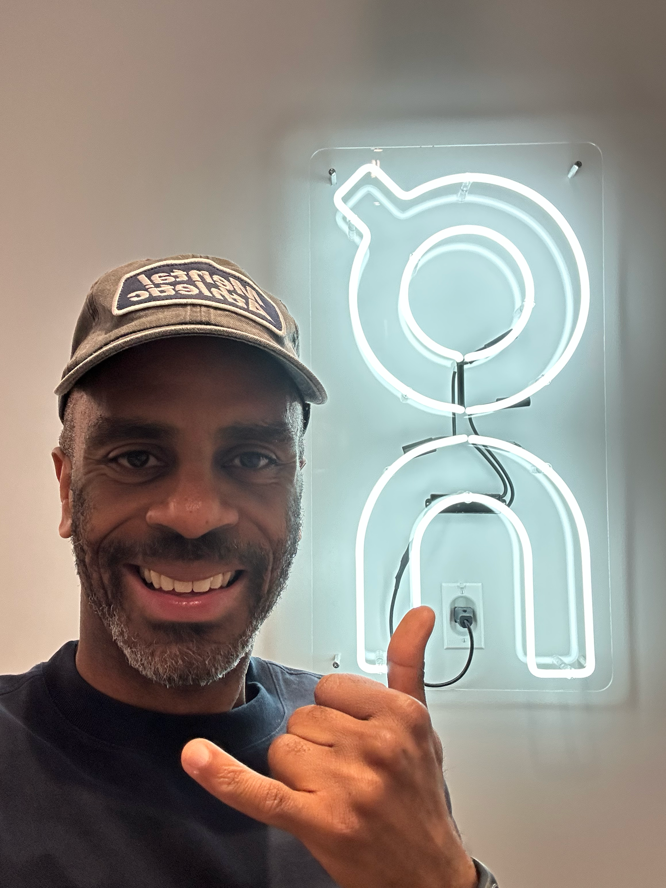 Sean Damian Tucker posing in front of On Running logo.
