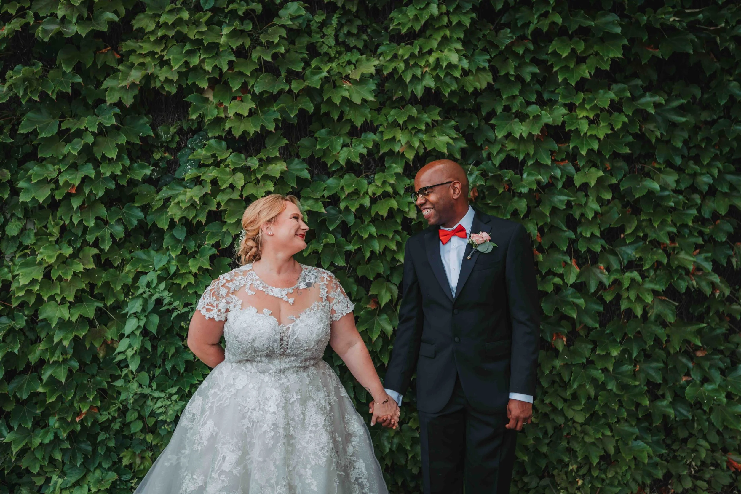 Upstate New York Interracial Couple holding hands in front of foliage