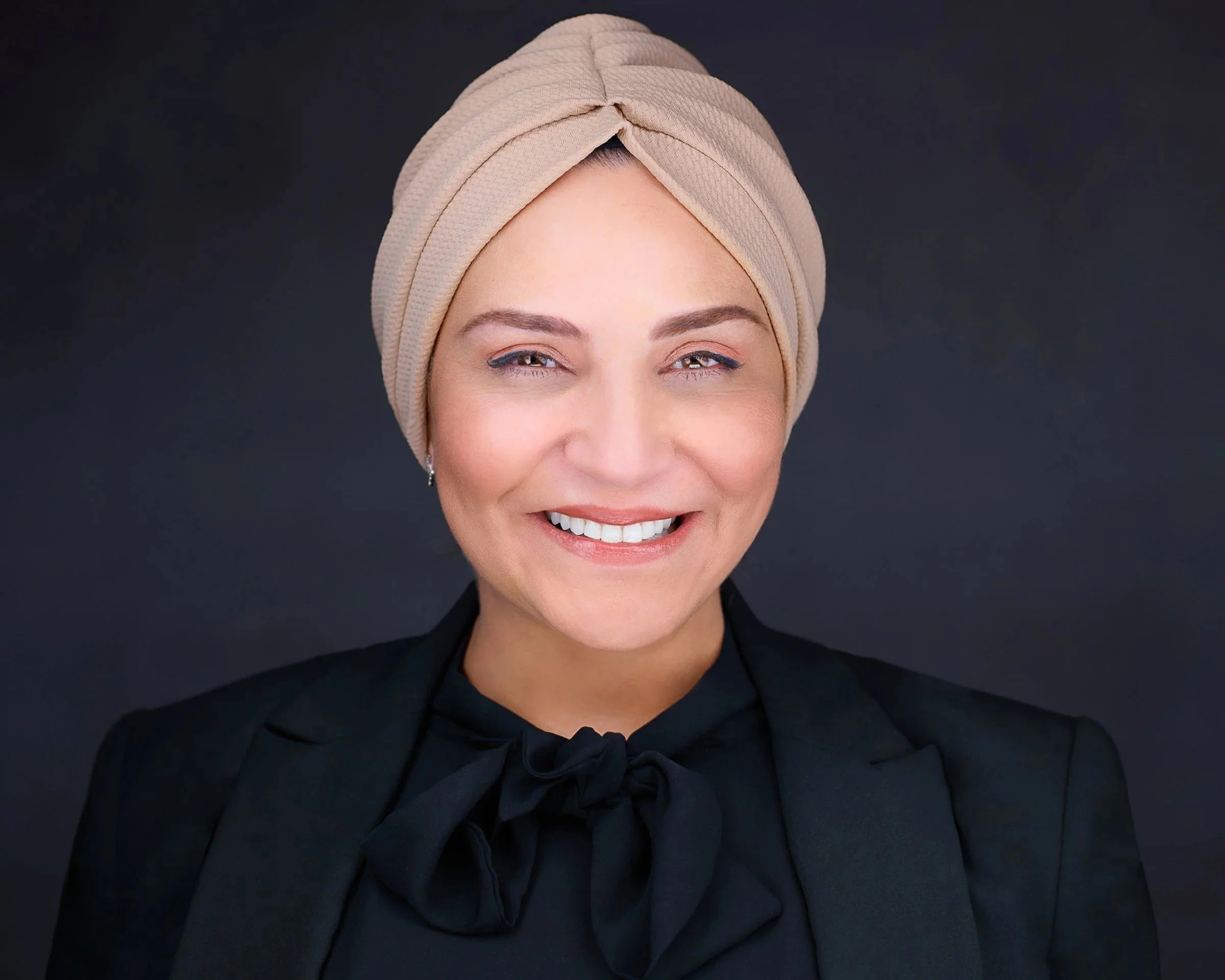 Reem Abousaif, headshot photographer in Irvine, in a black blazer and cream head wrap.