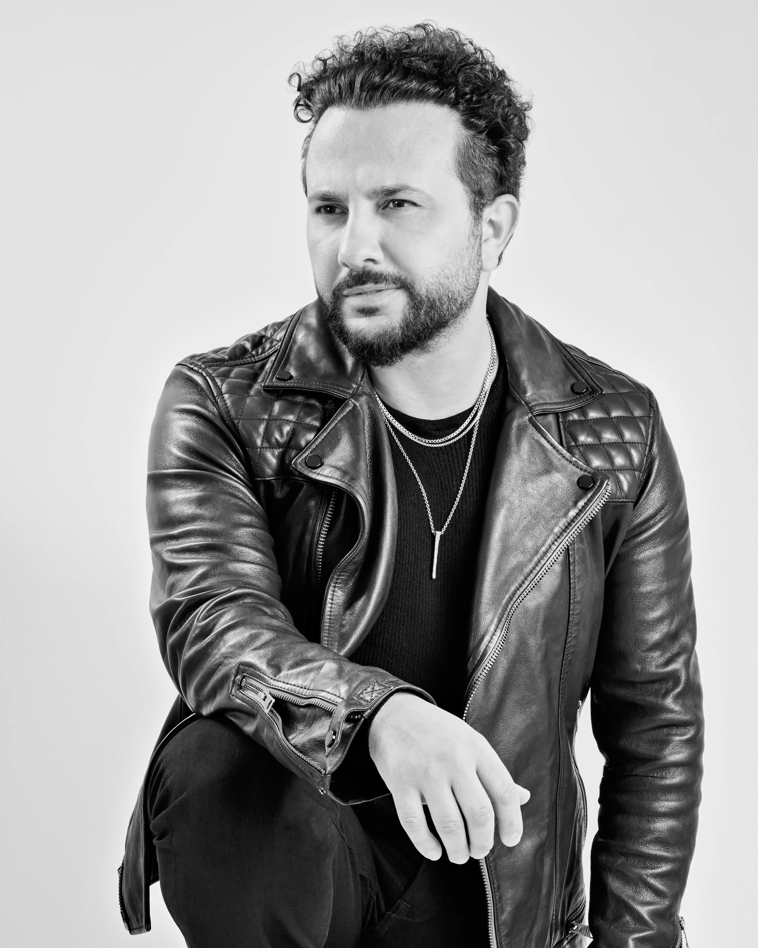 Black-and-white portrait of a bearded man in a leather jacket