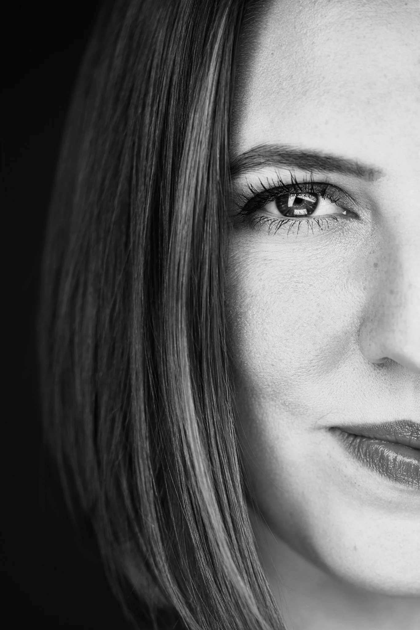 Black-and-white close-up of a woman’s face, half in frame