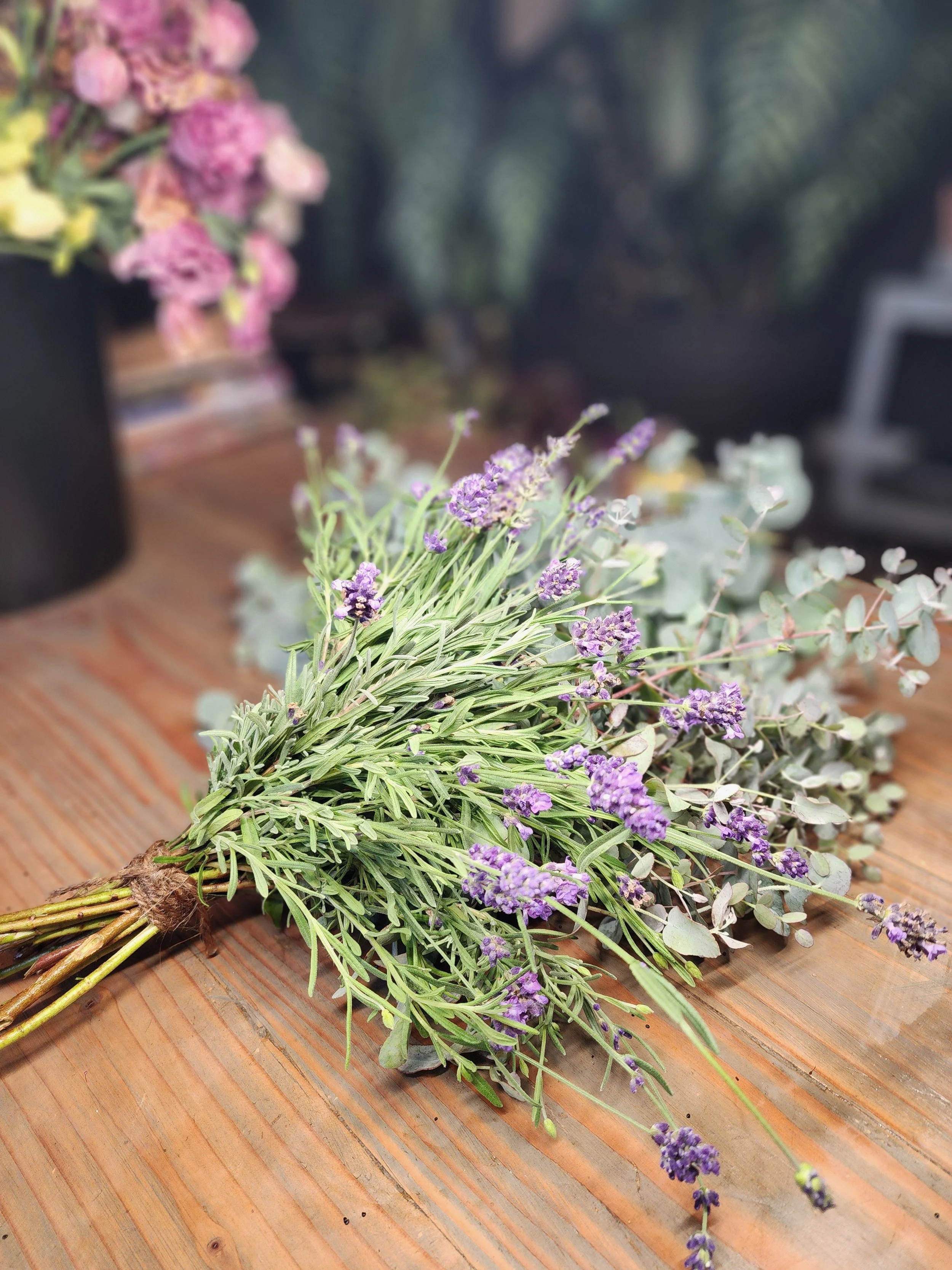 Bouquet of lavender and eucalyptus resting on a wooden table.