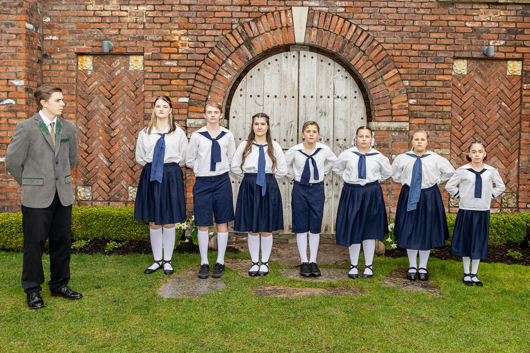 An actor looks at a group of seven actors who all stare straight ahead