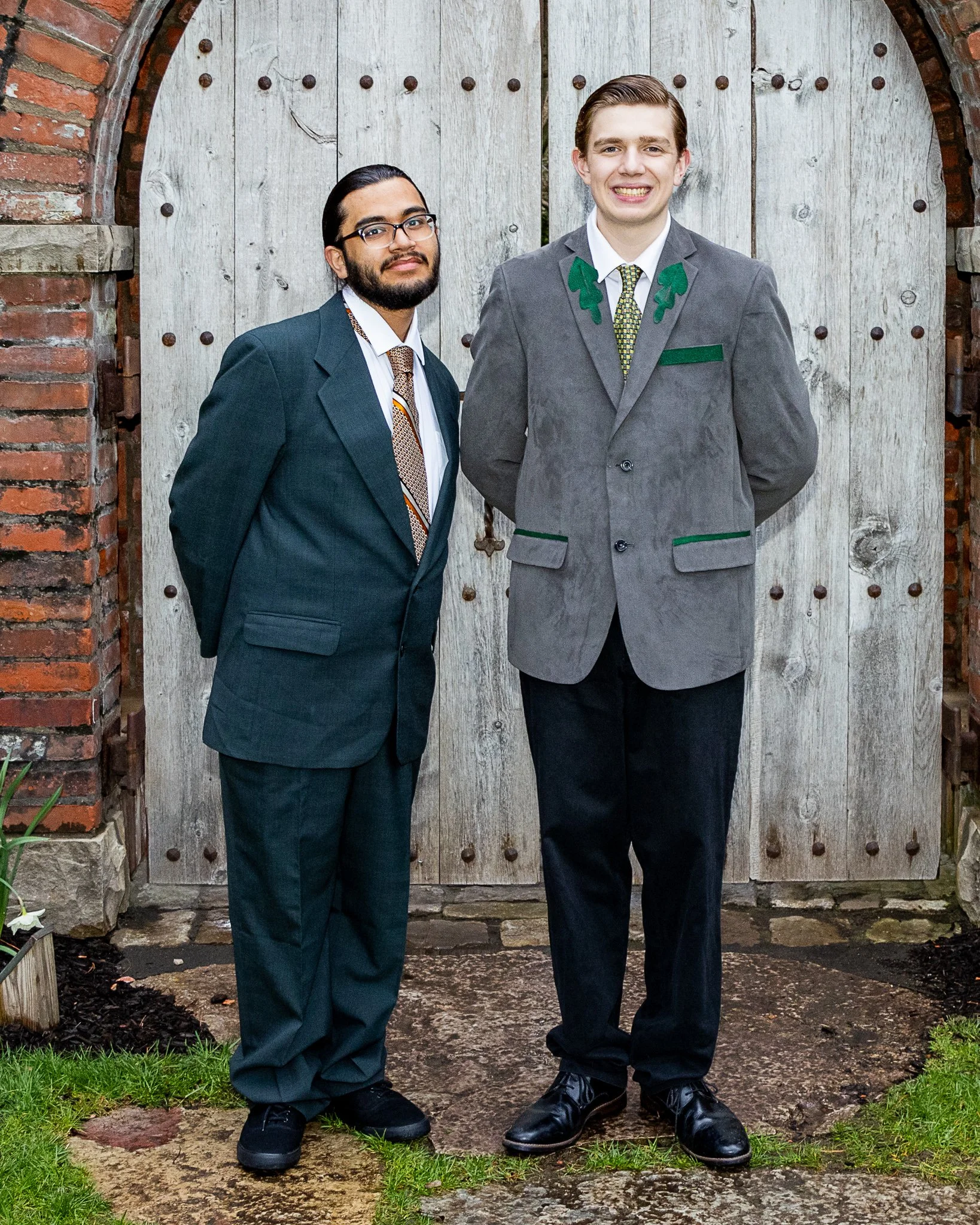 Two boys stand next to each other and smile