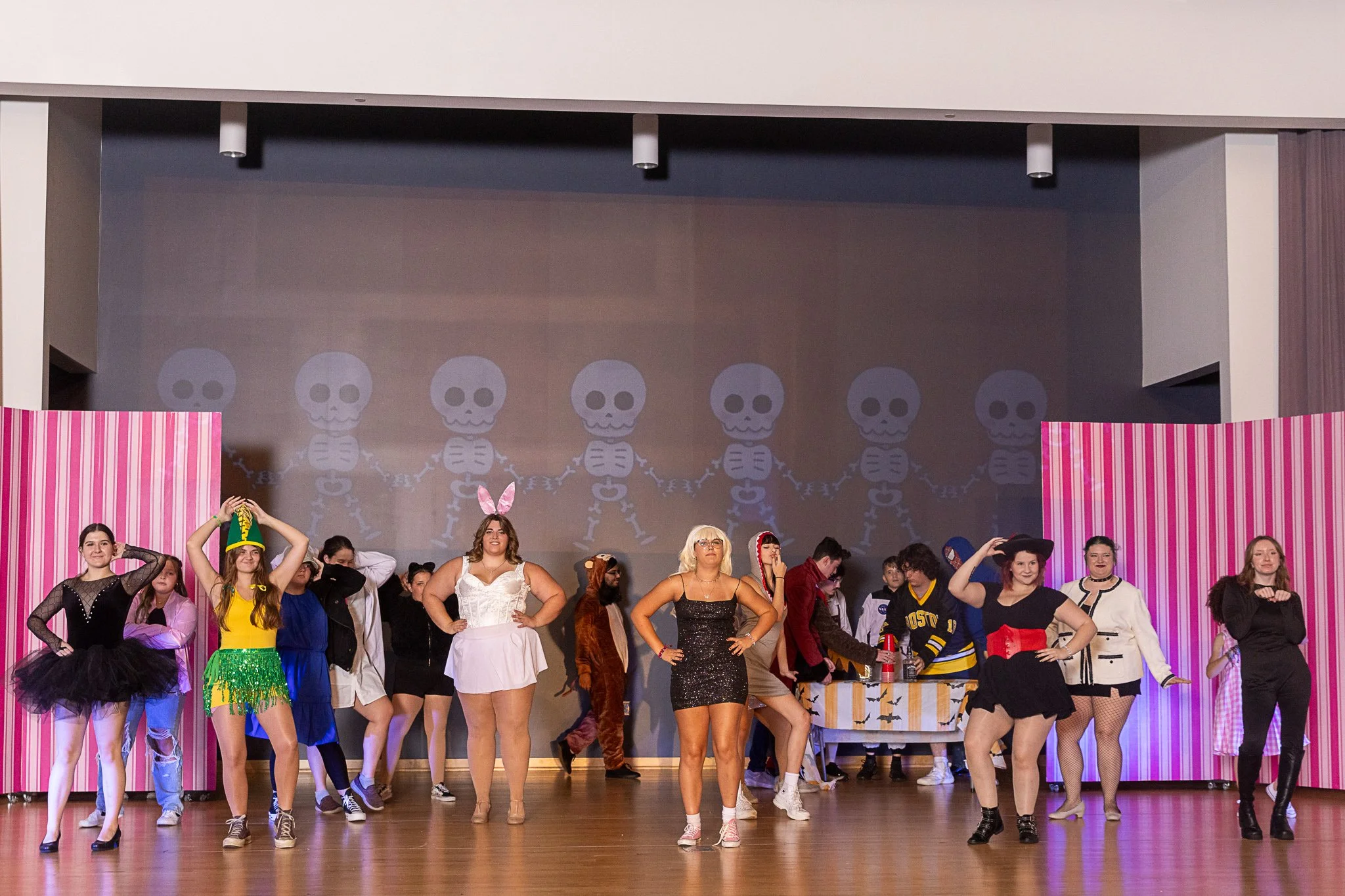 A group of girls in Halloween costumes dance together