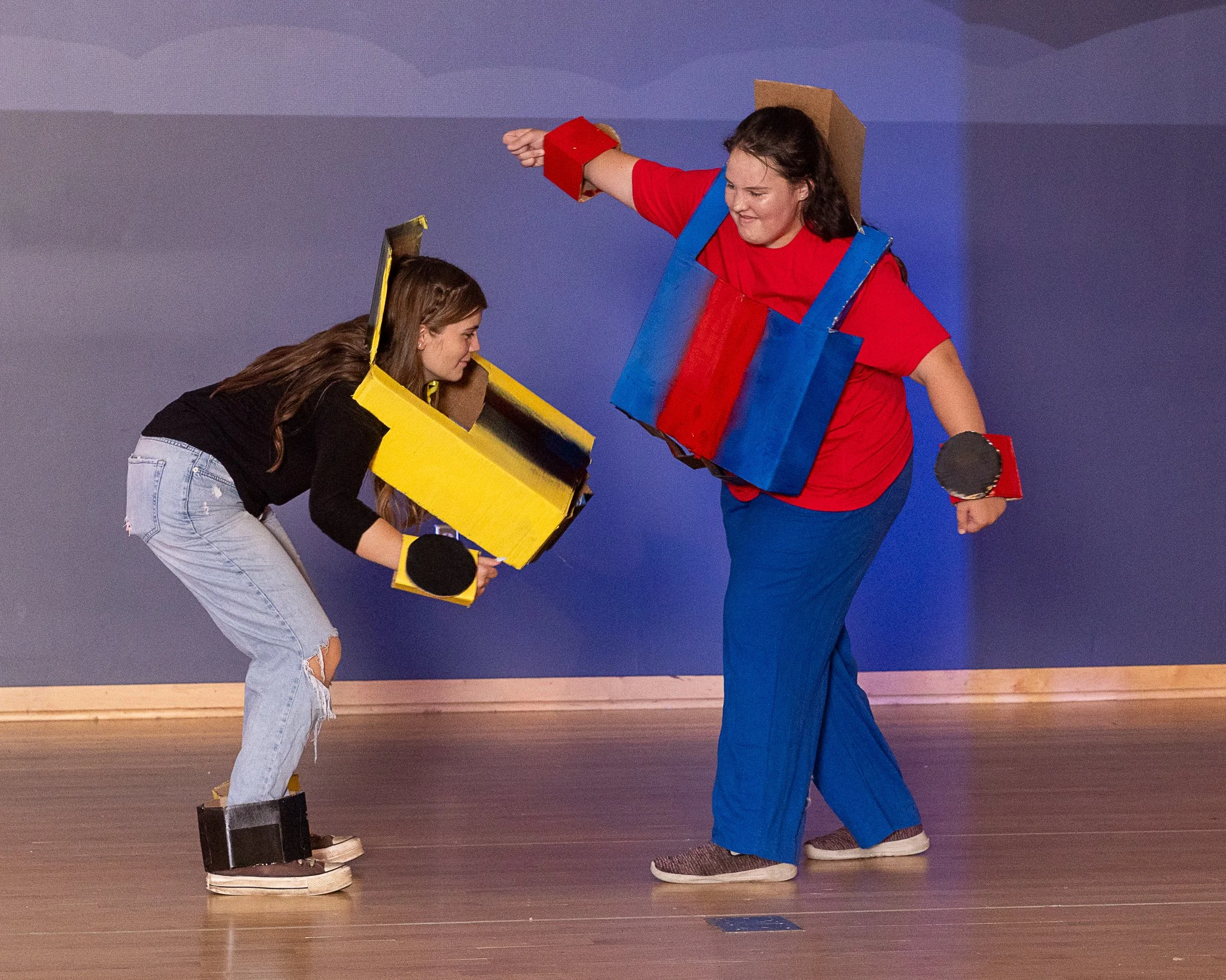 Two girls wearing transformers costumes pretend to fight