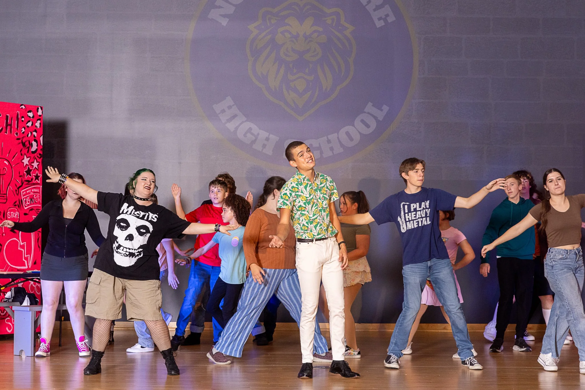 A boy sings in the middle of an ensemble of dancers