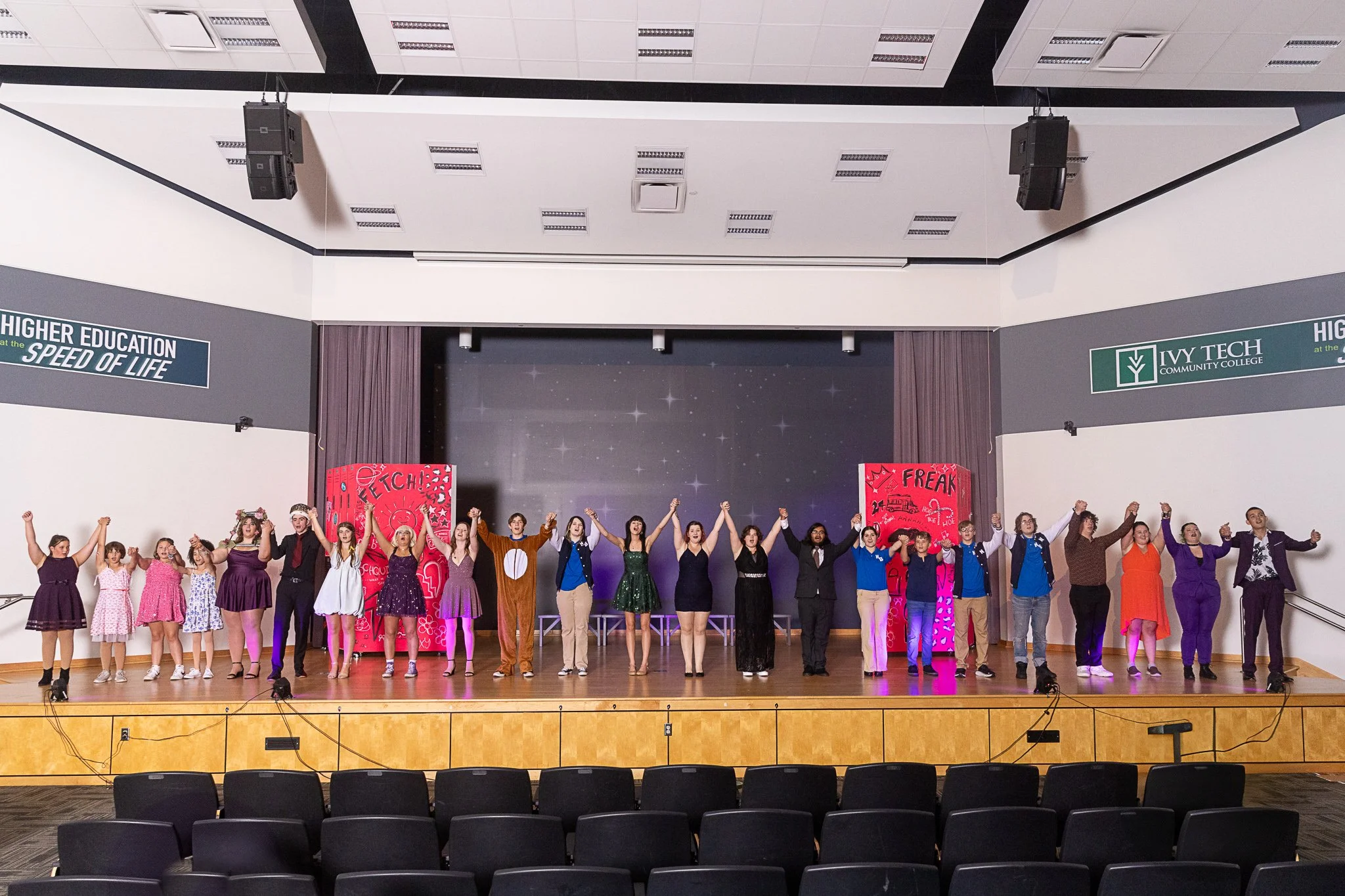 The cast of Mean Girls: High School Edition holds hands and sings