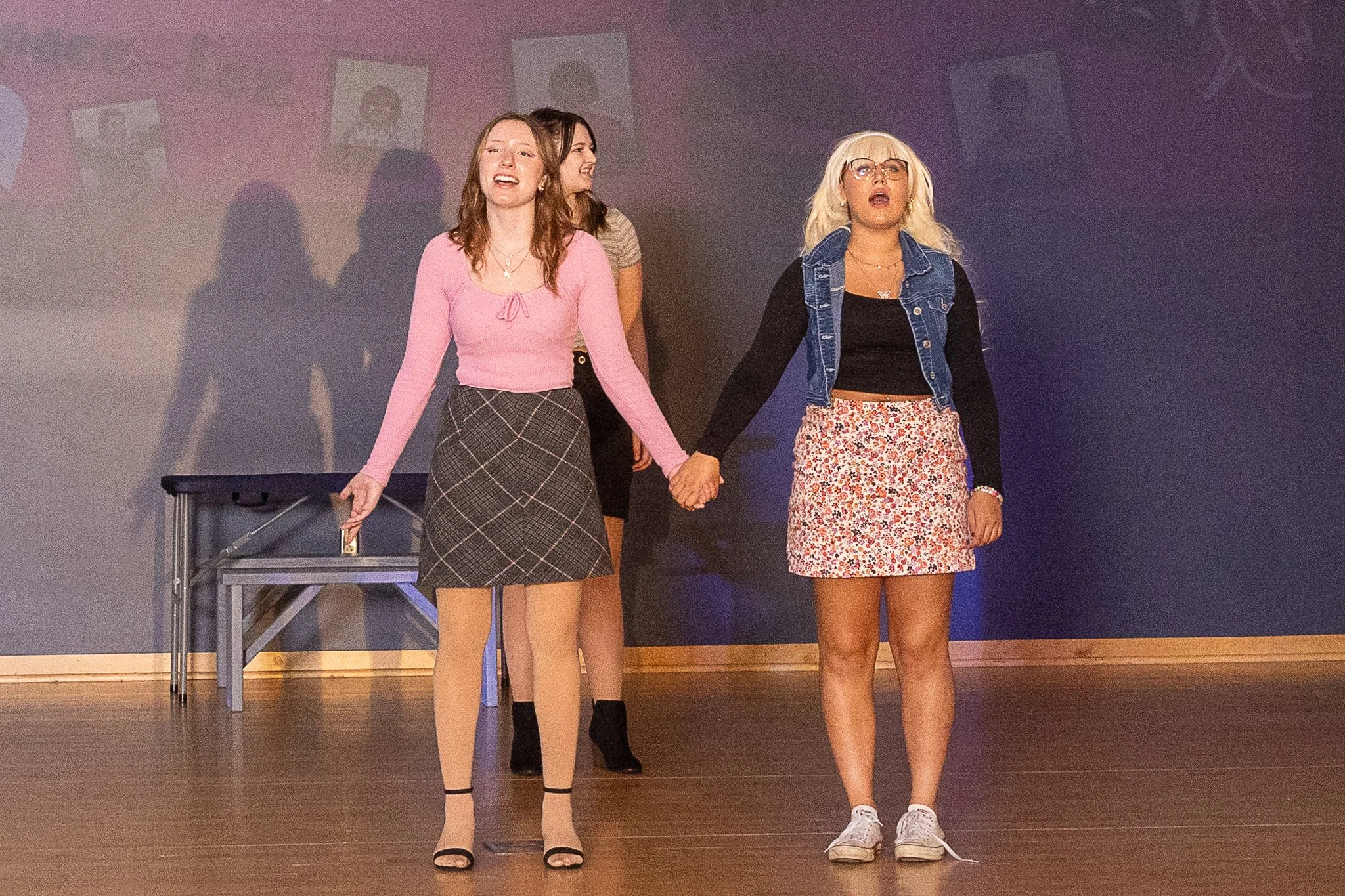Two girls hold hands and sing