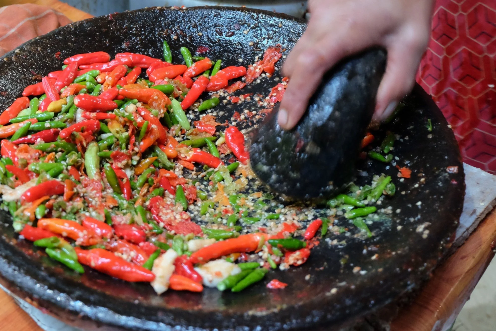 female-hand-grinding-red-and-green-chilli-on-stone-2024-02-12-15-33-09-utc.jpg