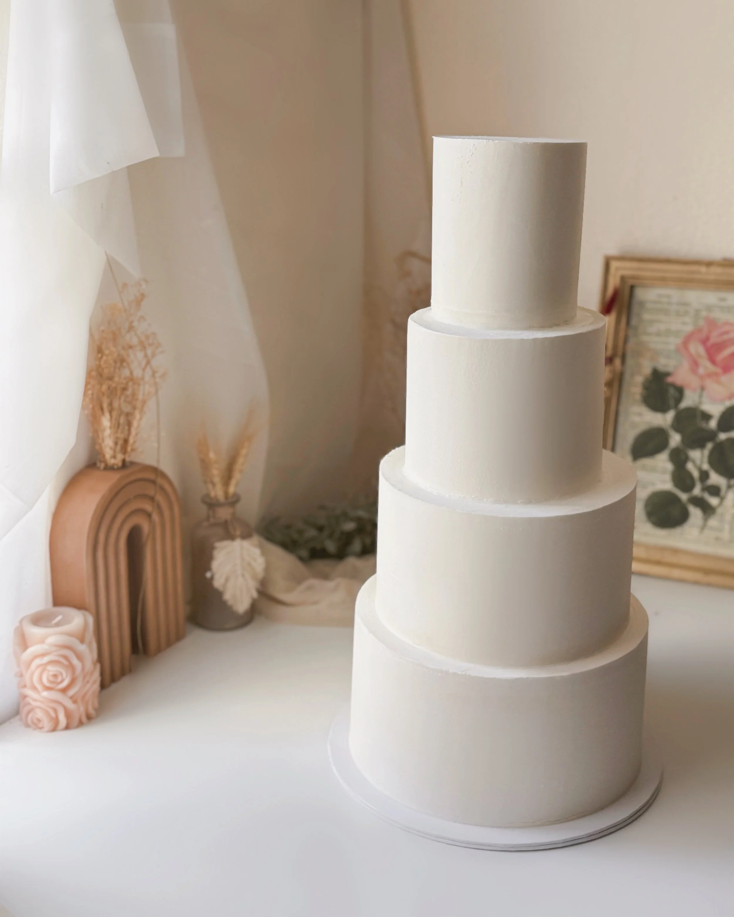 White four-tiered cake with no decorative elements.
