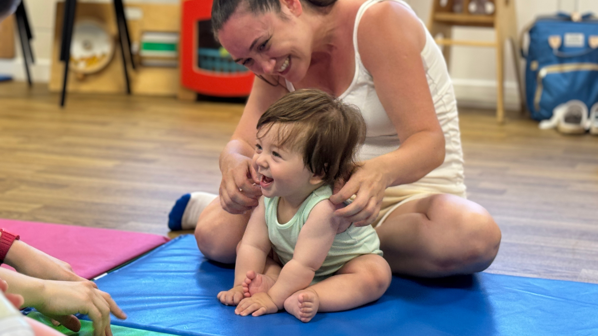 A parent and baby taking part in a MoveBaby session on floor mats