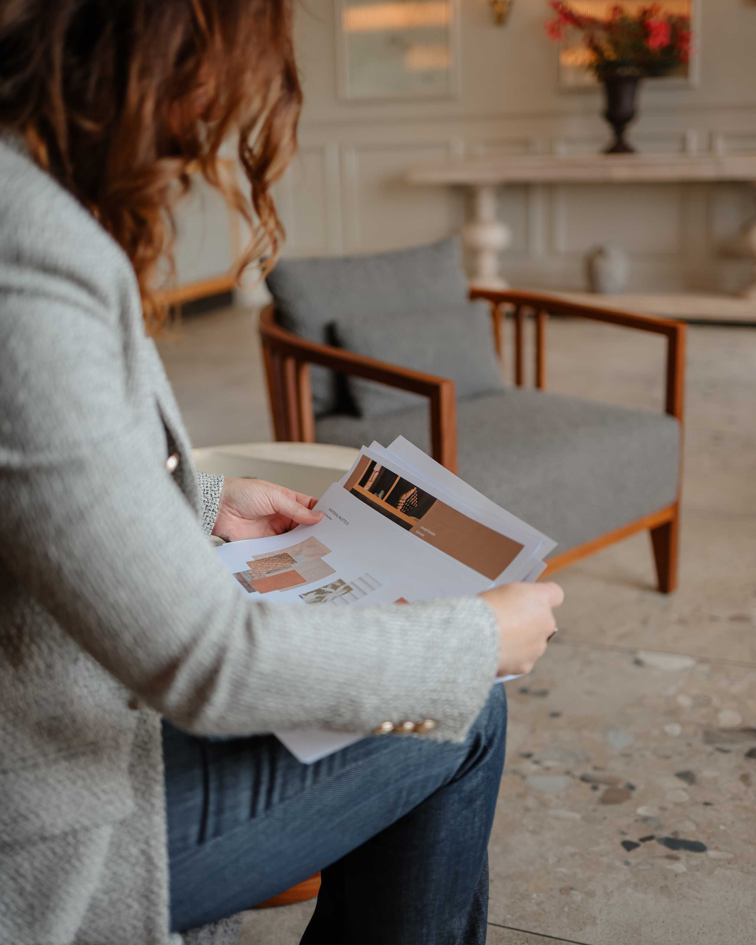 Woman sitting down with interior design images.