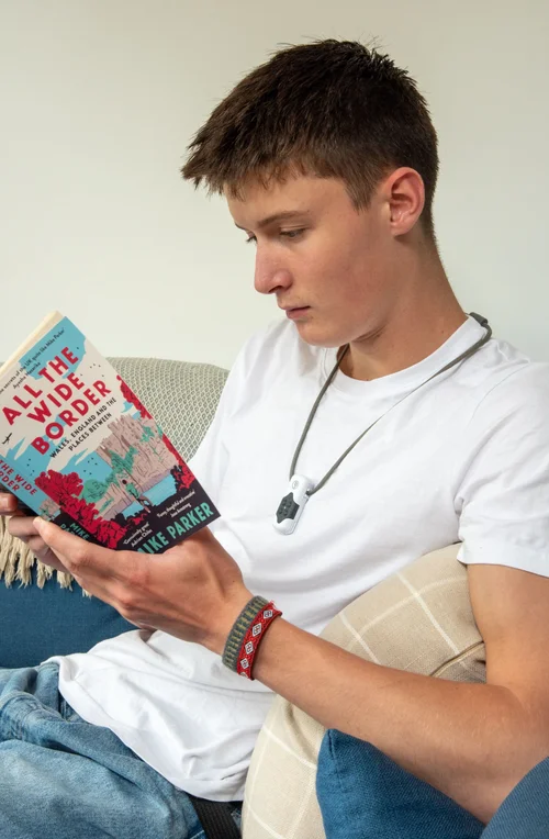 Person reading while wearing TinniSoothe