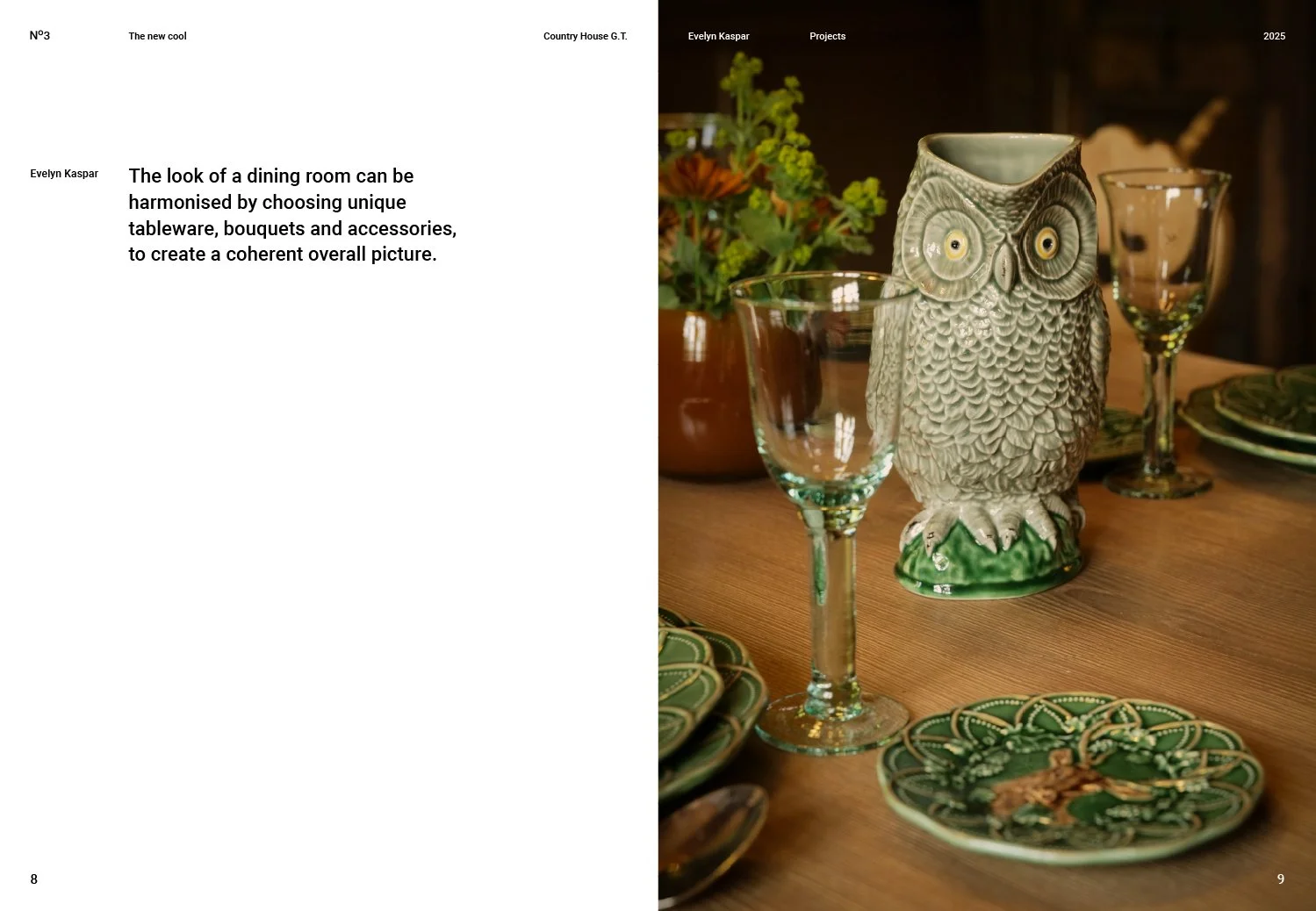 A wooden dining table set with green patterned plates, a glass owl-shaped vase, two empty wine glasses, and a potted plant with yellow flowers in the background.