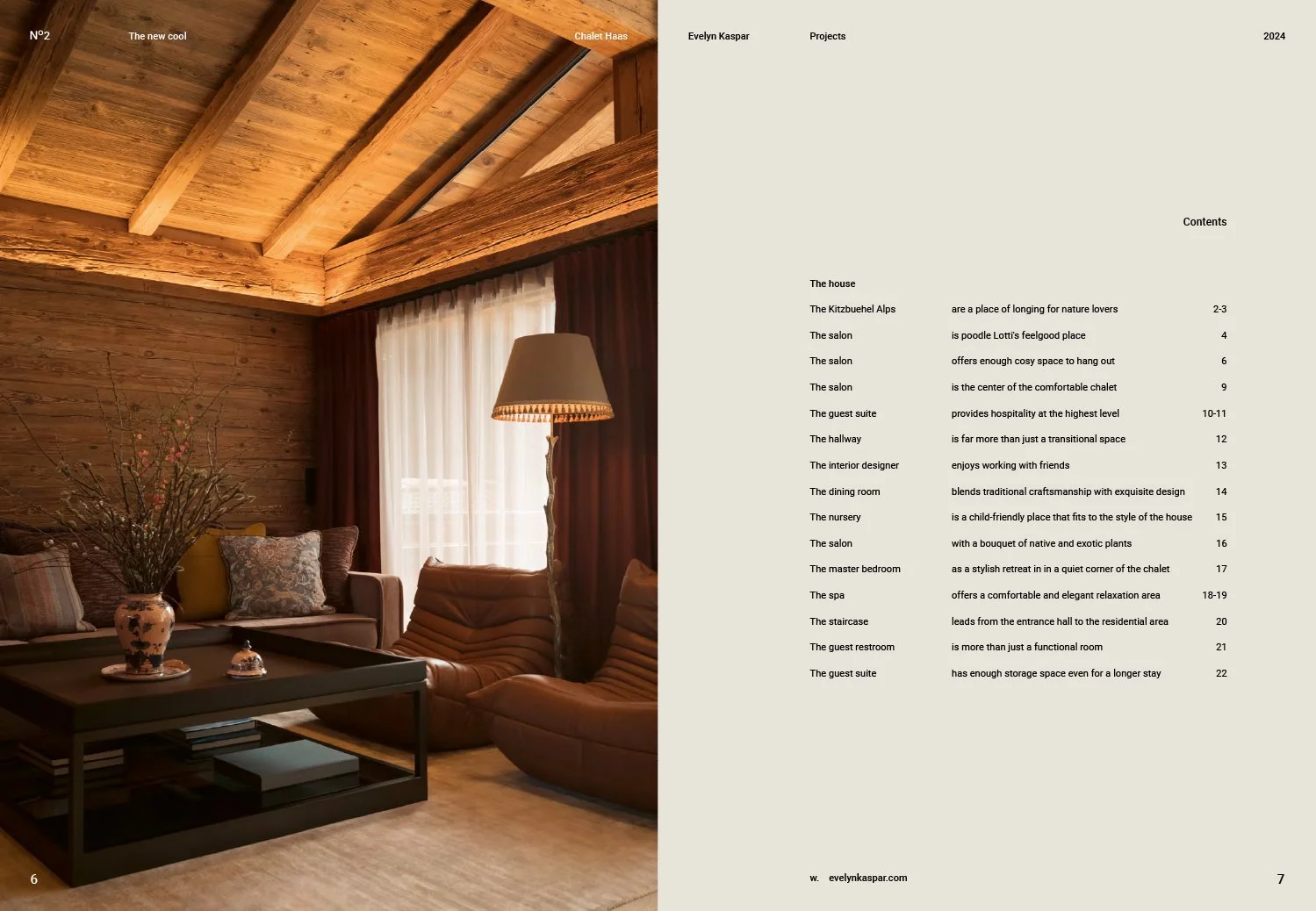 A cozy living room with wooden walls and ceiling, featuring a beige sofa with patterned cushions, a dark coffee table with books underneath, a tall standing lamp, and large windows with sheer curtains and dark drapes.