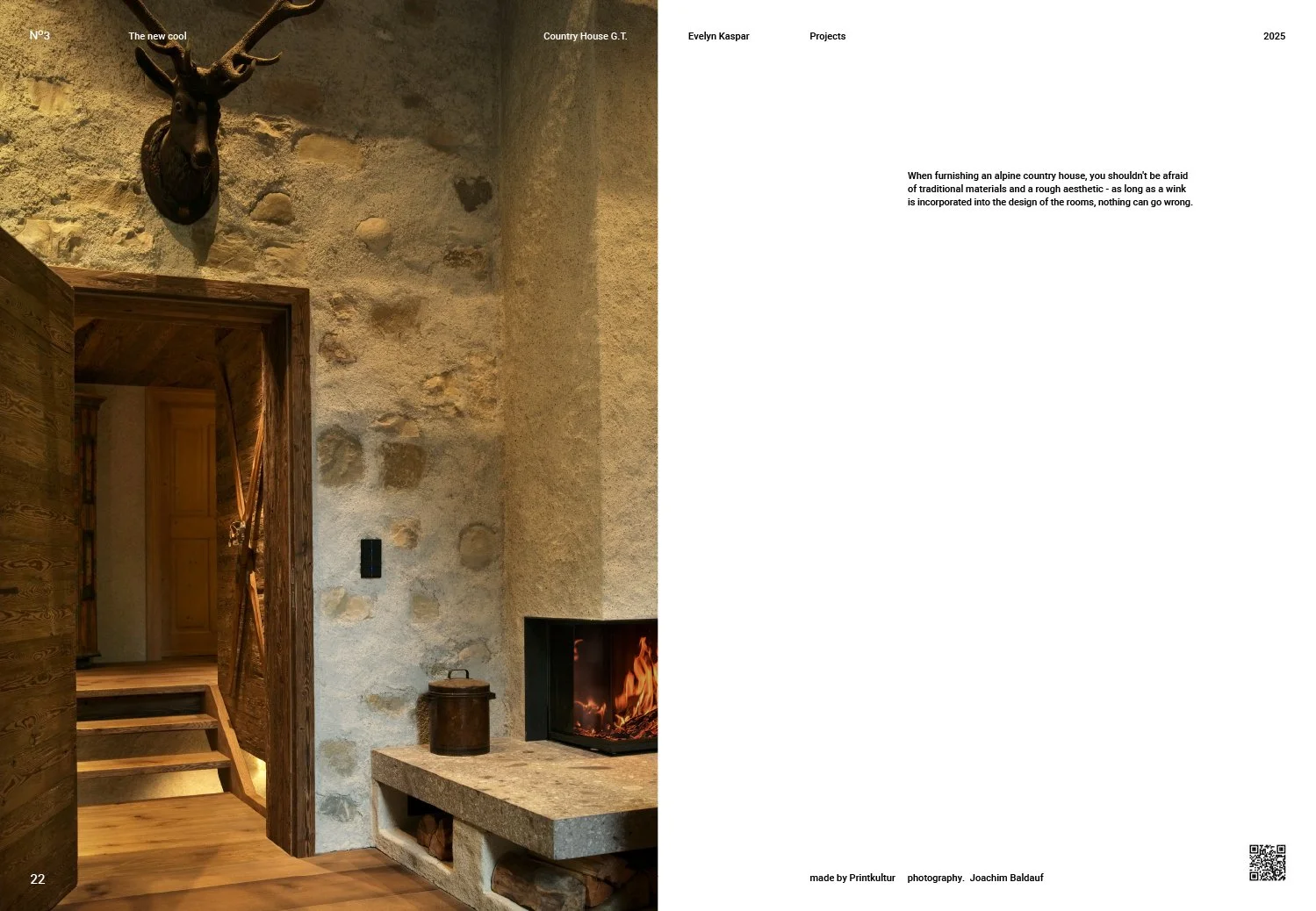 Interior of a rustic country house with a stone wall, a deer head mounted on the wall, a wood door, a stone fireplace with fire burning, and a small metal container on the hearth.