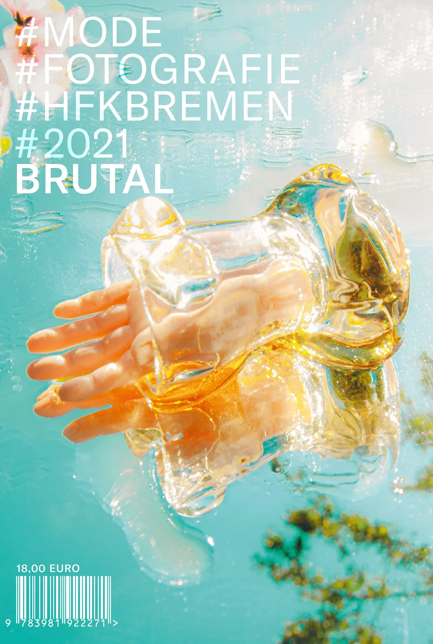 A hand holding a clear glass sculpture of an ice cube over a blue water surface, with sunlight reflecting off the water.