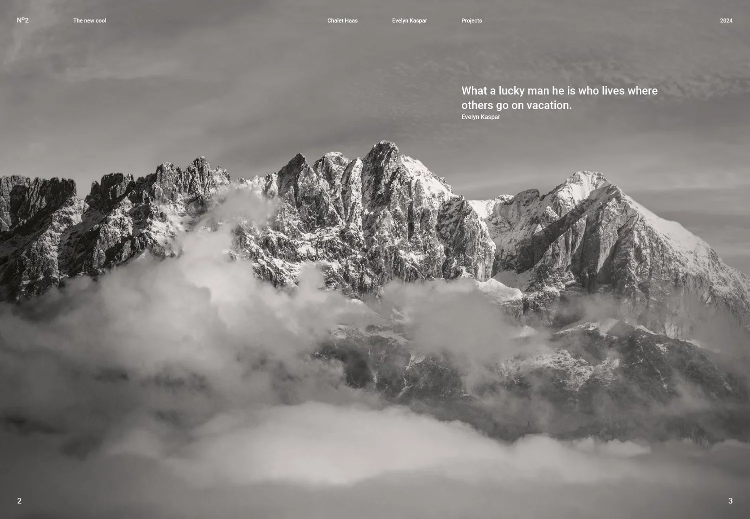 Black and white photograph of a snowy mountain landscape with clouds at the base.