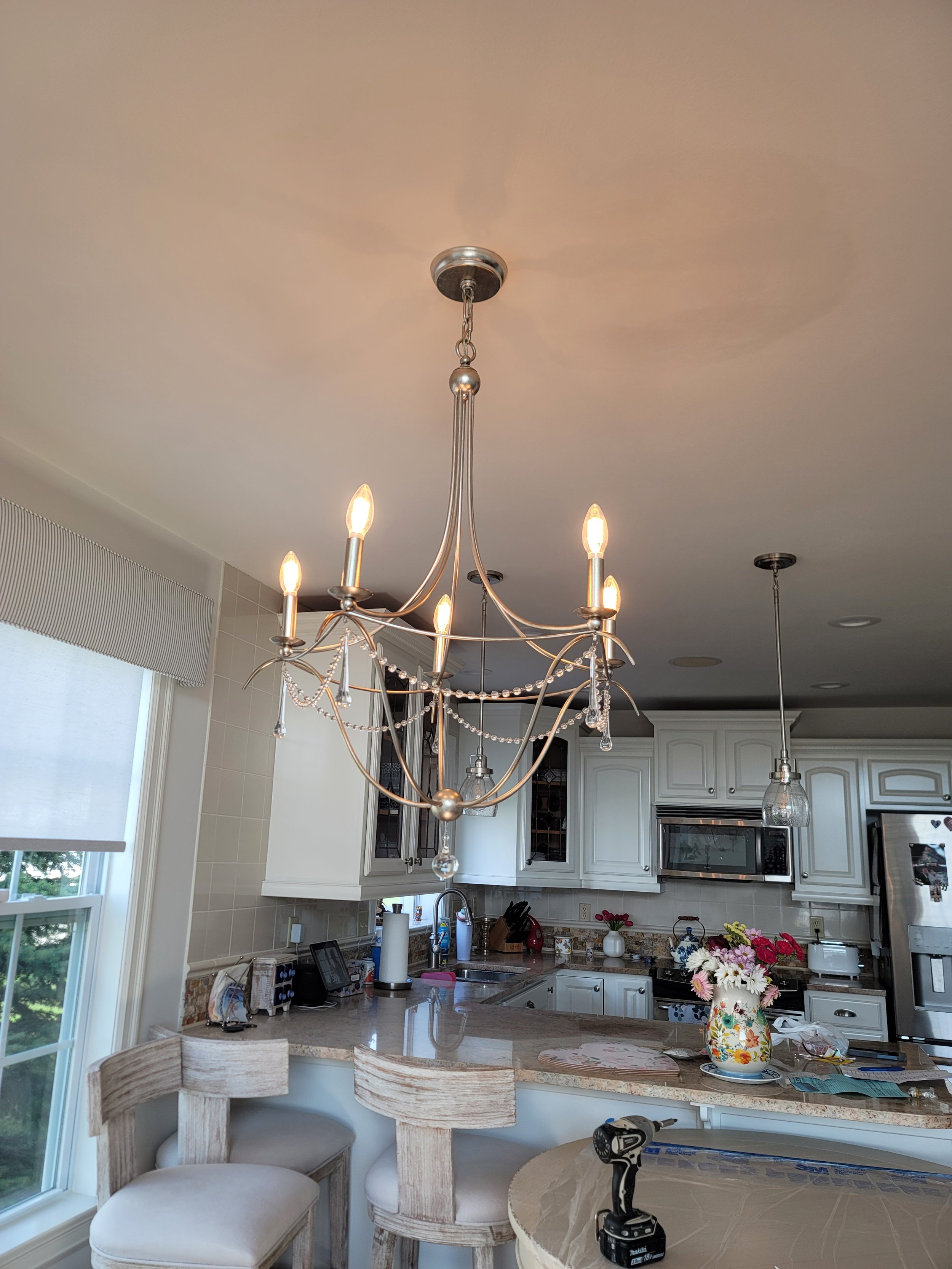 Moved Chandelier over the center of table. Extended electrical to chandelier, patched and finished ceiling to match