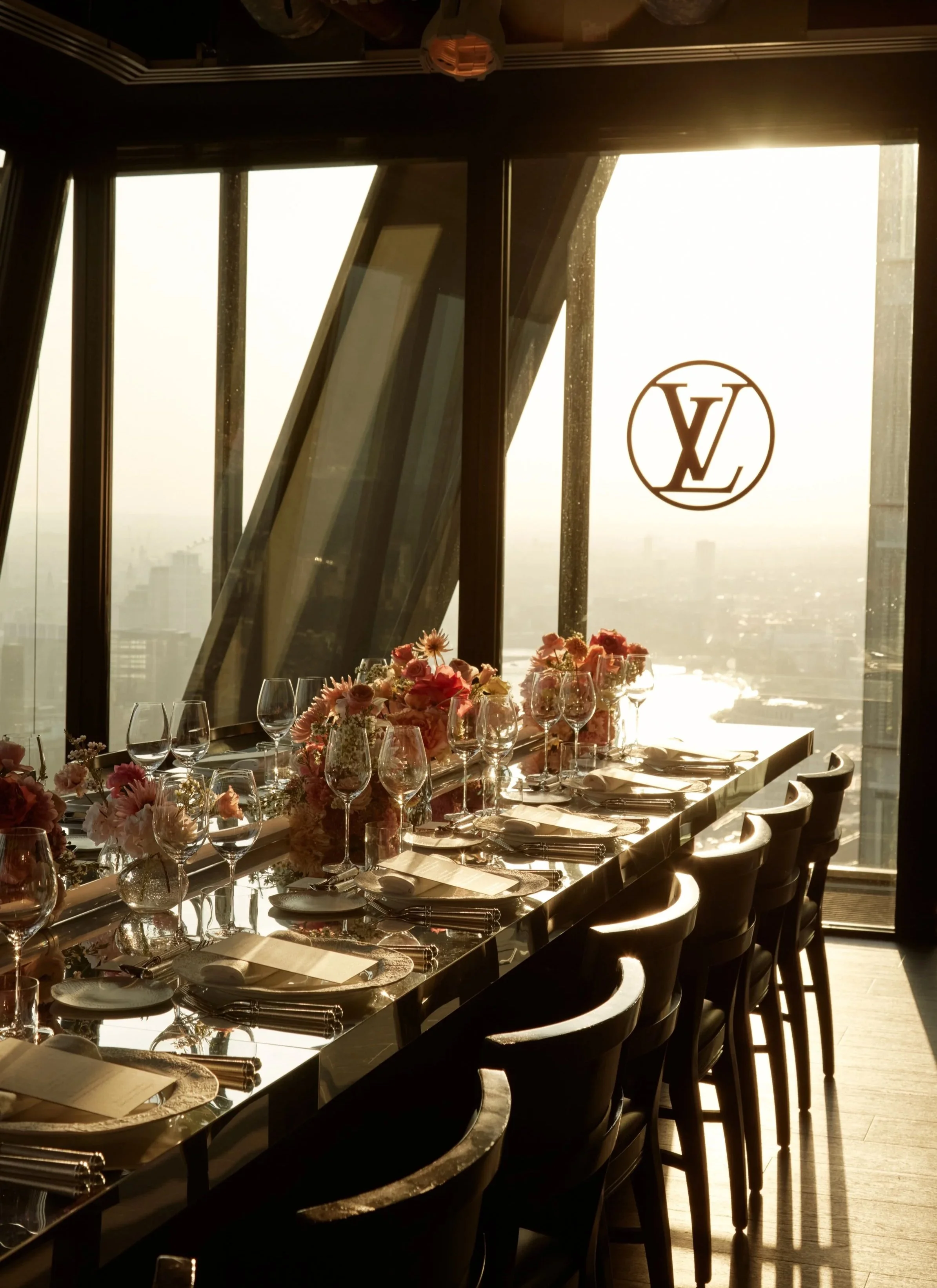 Dinner in the sky for Louis Vuitton, featuring a timeless tablescape with soft pink flowers delicate glassware and a delicious three course meal