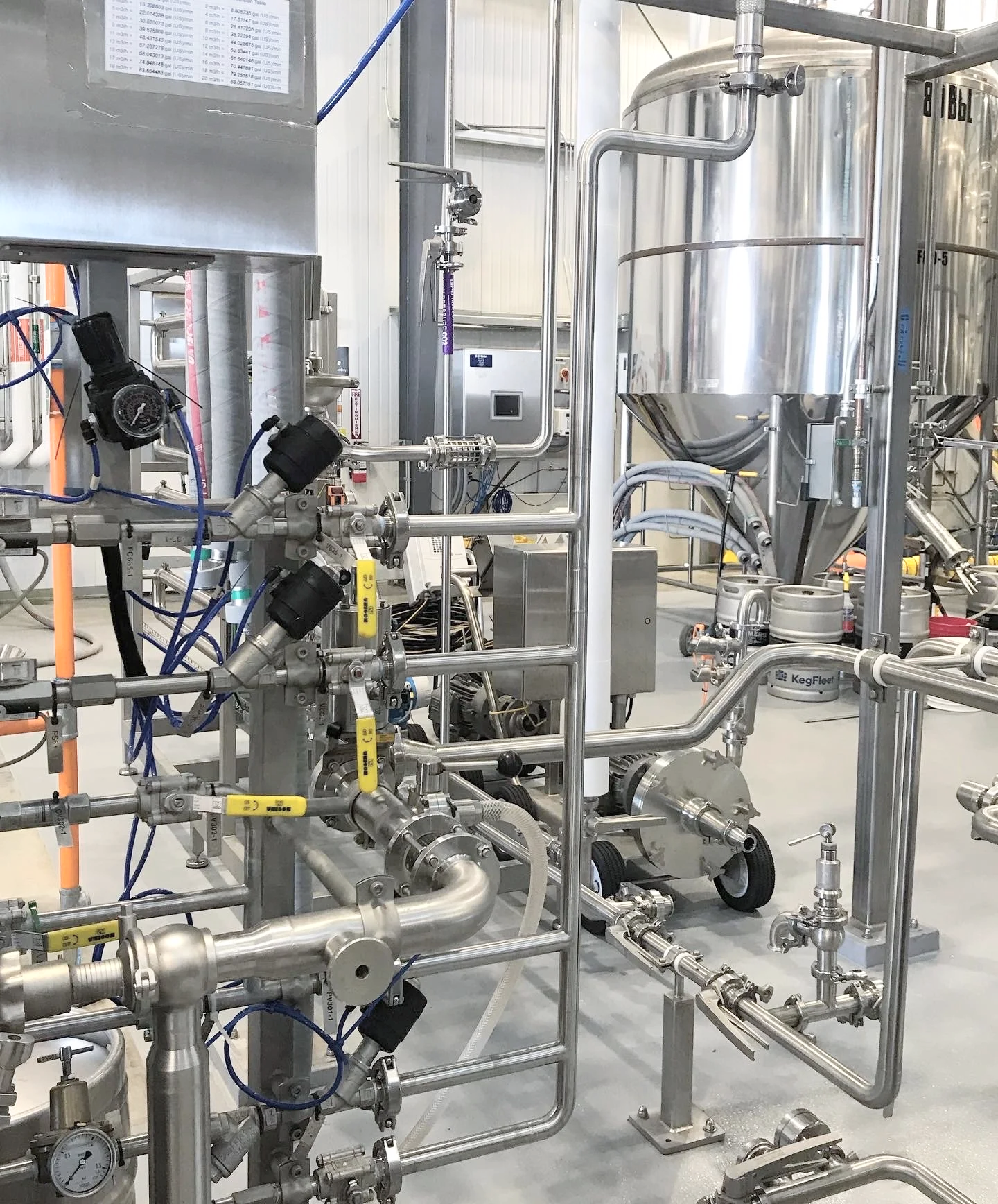 Industrial stainless steel pipes and tanks in a manufacturing or processing facility.