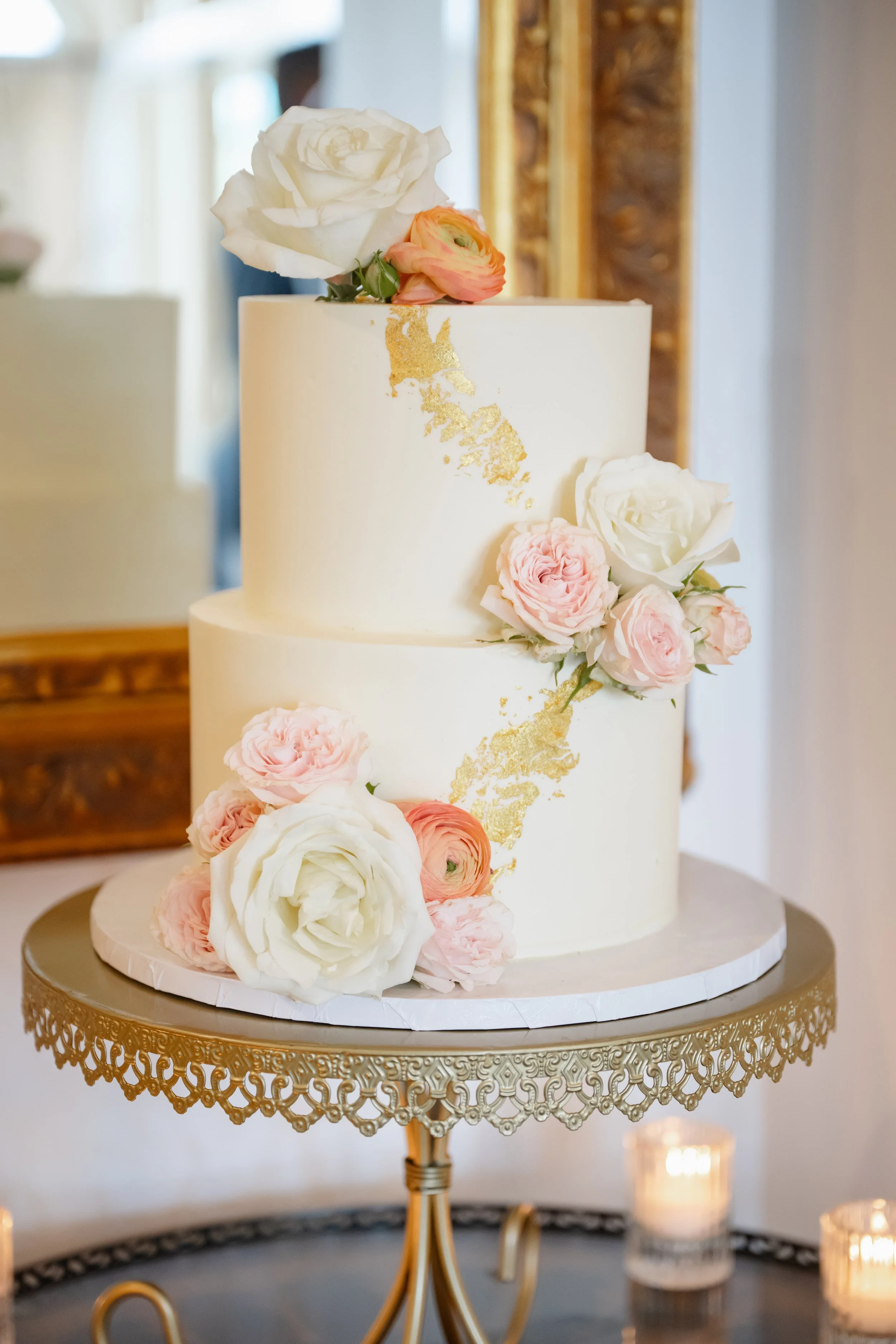 Smooth white buttercream. Gold leaf. Fresh flowers in alternating clusters..jpg