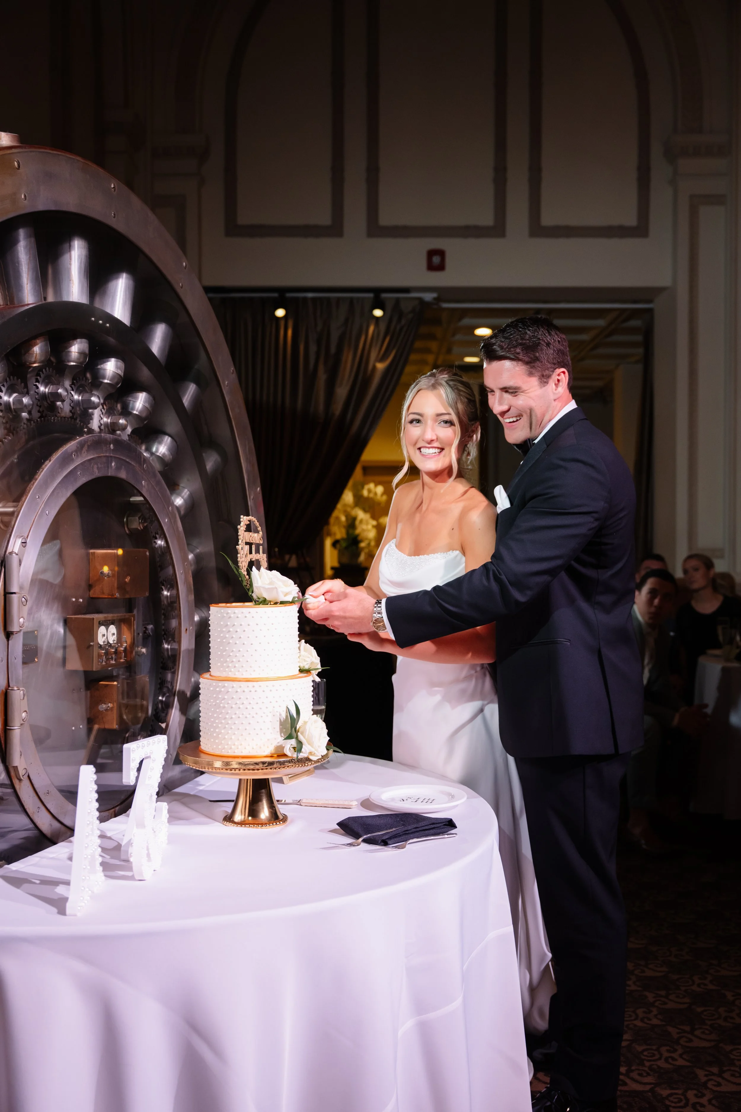 bride and groom cake cutting, smooth white buttercream with buttercream bead piping and gold fondant (round borders). Fresh flowers 1.jpg