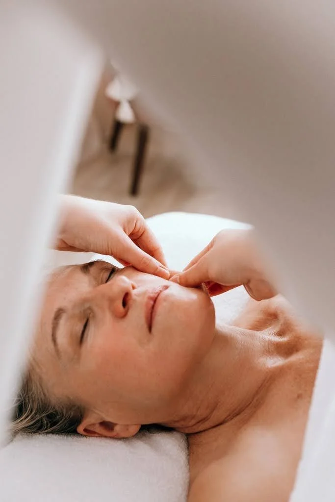 Une personne reçoit un soin du visage ou un massage facial dans un cadre intérieur