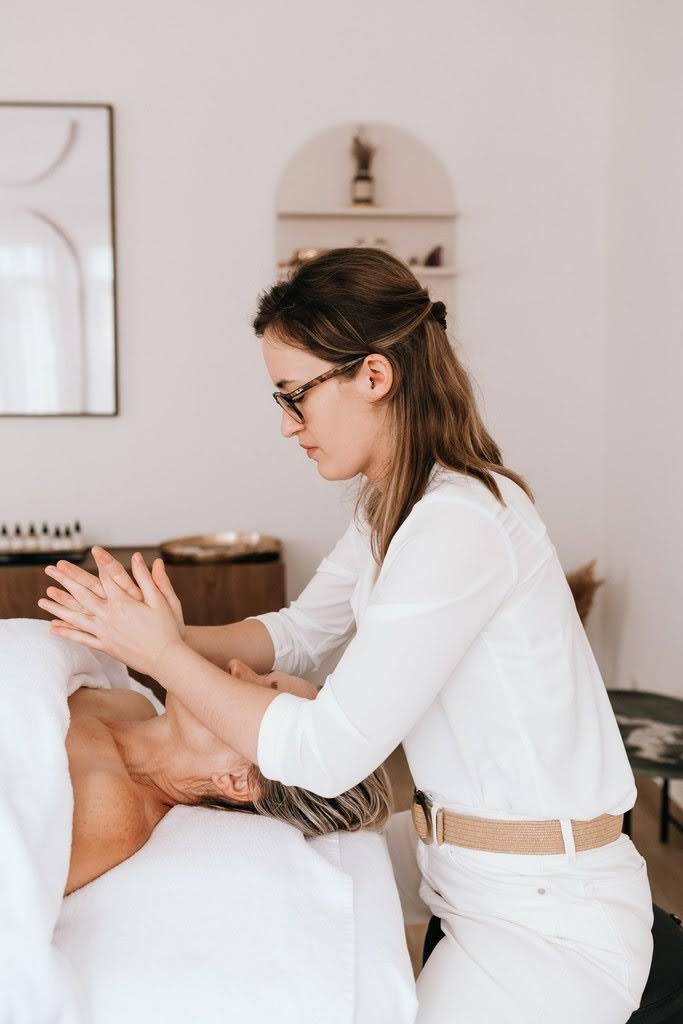 Une femme soignant une personne âgée lors d'un massage ou d'une séance de relaxation.