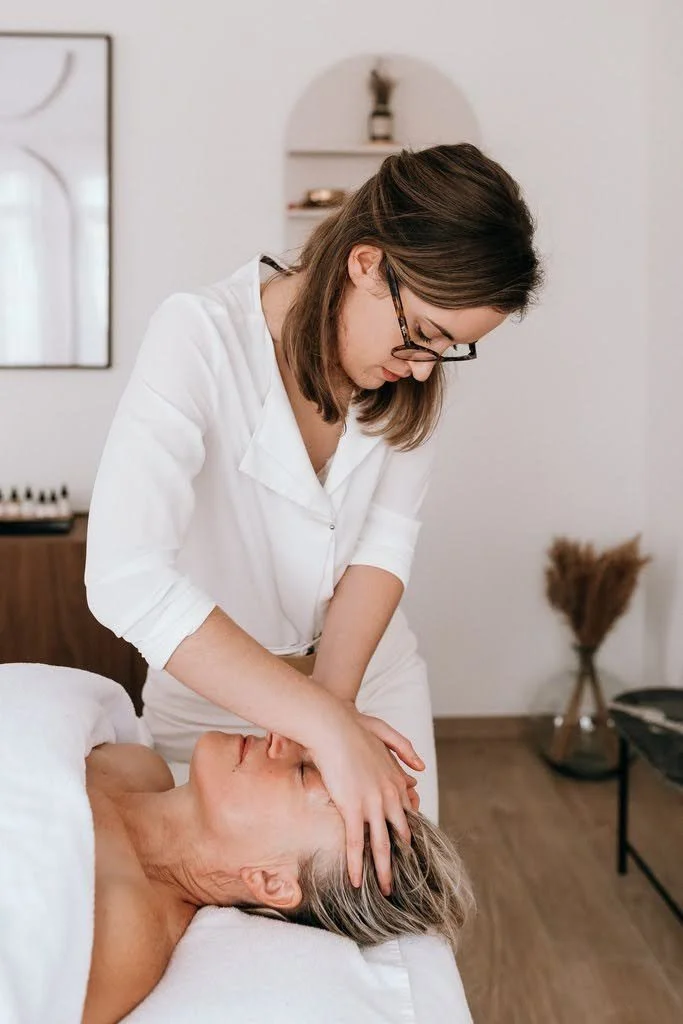 Une femme reçoit un massage de la tête dans un cadre apaisant.