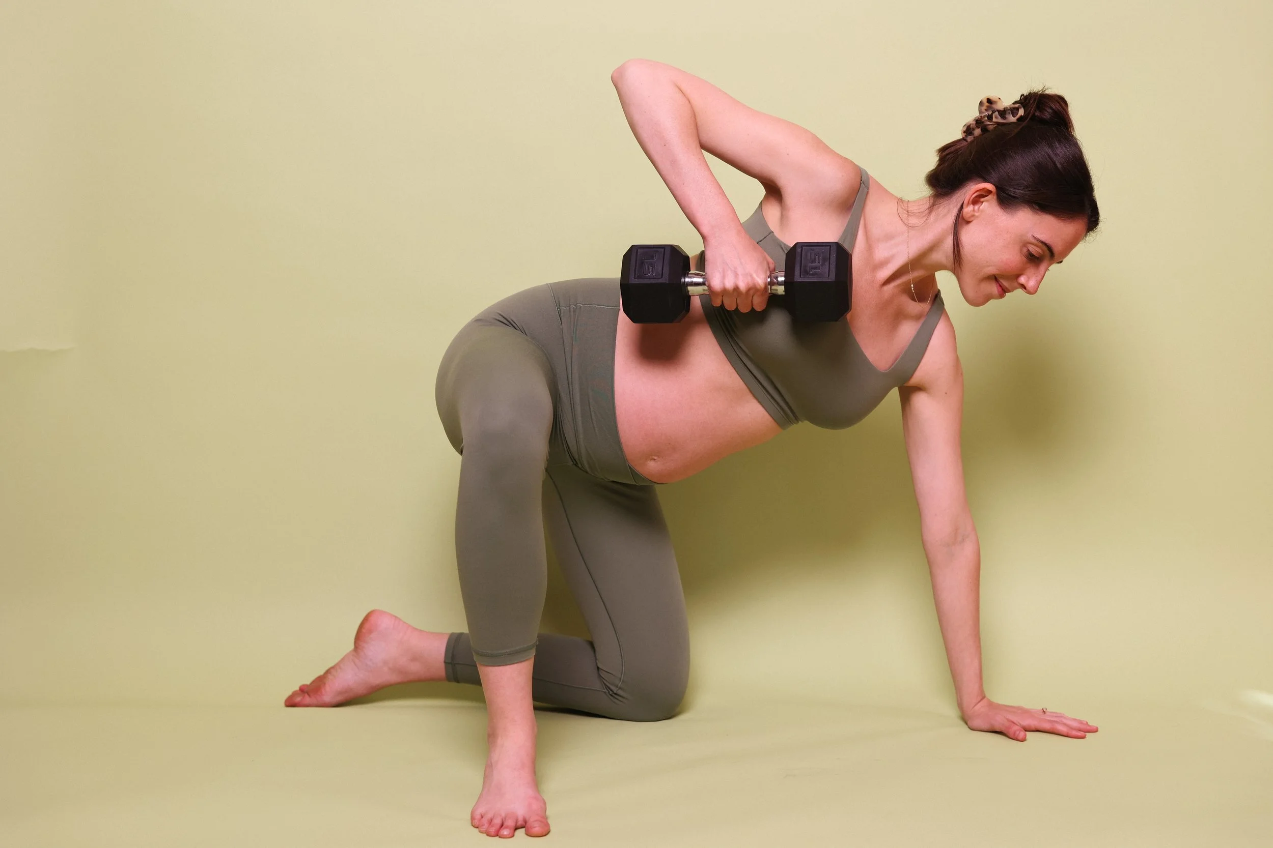 Pregnant woman performing a strength training exercise, demonstrating safe and functional prenatal fitness.