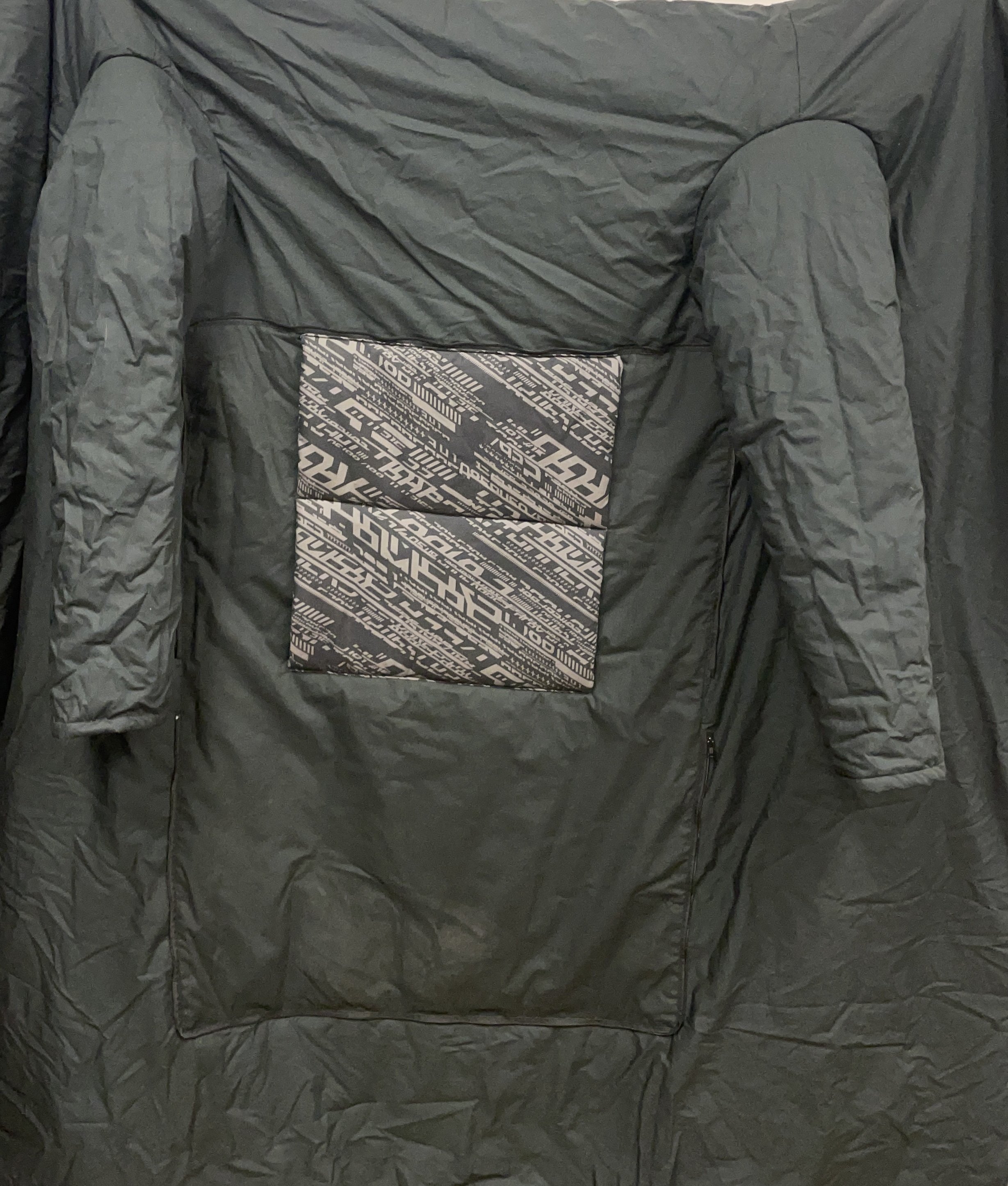 Couverture/manteau pliable en coussin, noire et grise.