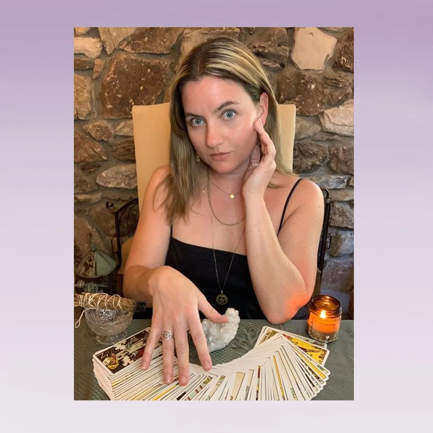 Woman sitting at a table with tarot cards fanned out in front of her