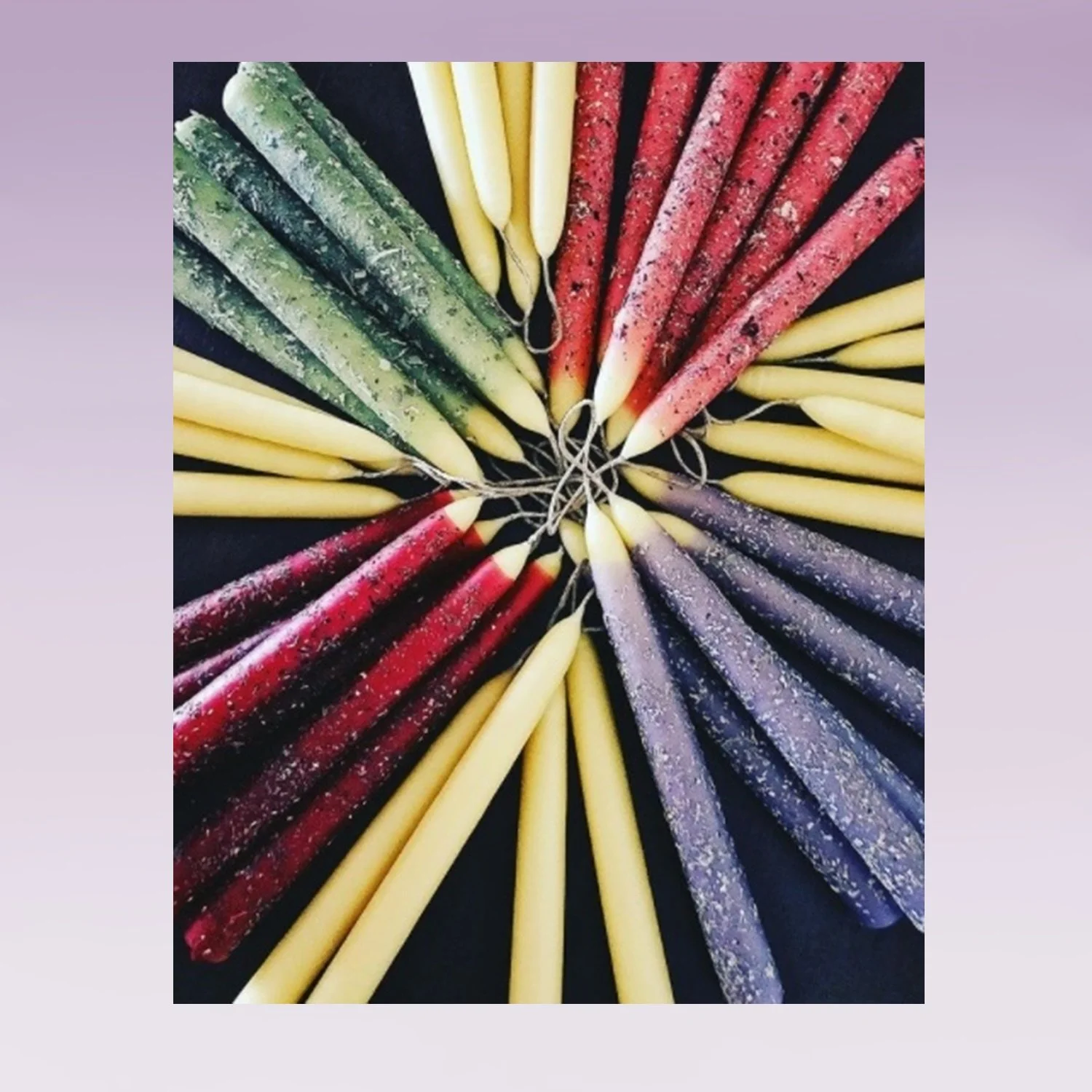 image of multicolored candles arranged in a circle, wicks inward