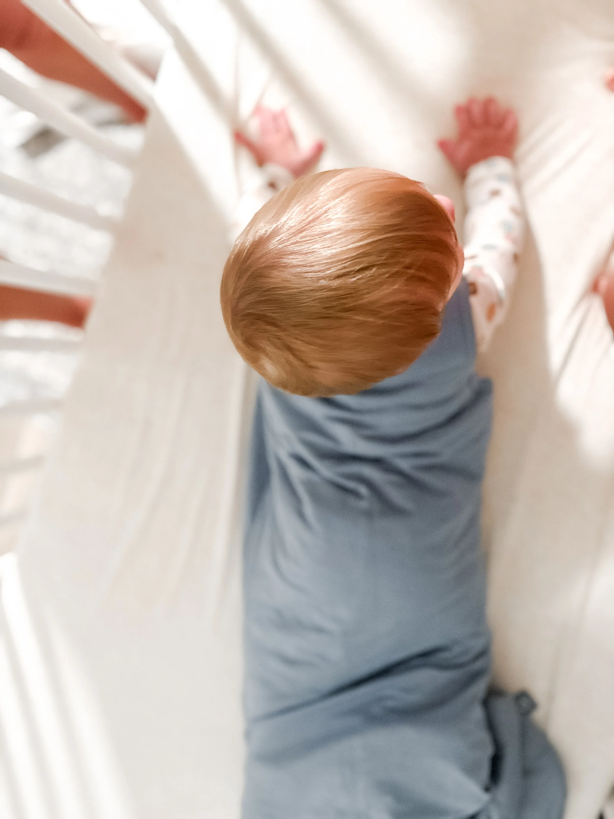 6-month-old sleeping in Momcozy sleep sack in crib.