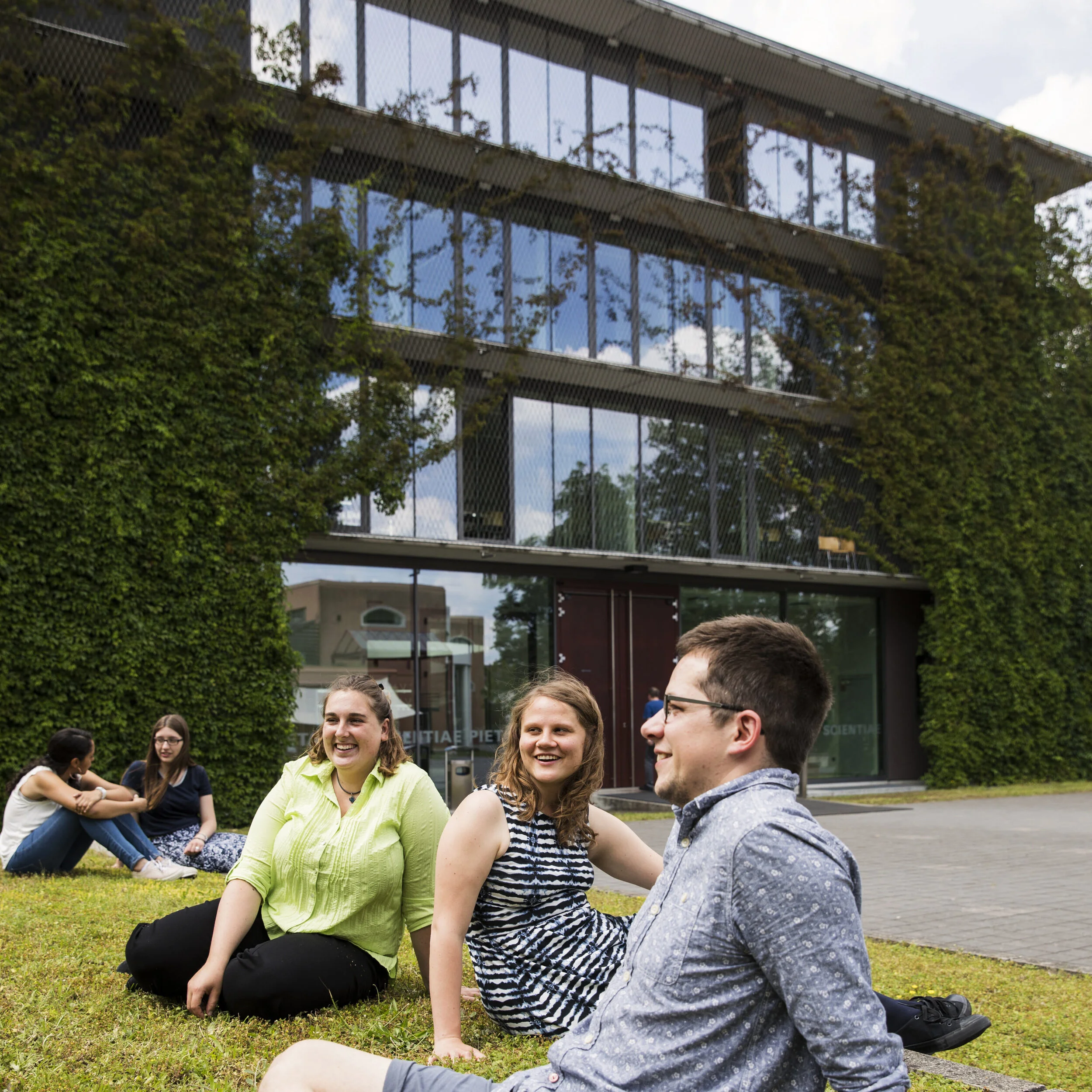 Gruppe junger Studenten vor dem Hauptgebäude auf dem Campus der Hochschule Sankt Georgen in Frankfurt am Main: Architektur und Hochschulfotografie von Angelika Zinzow Fotografie